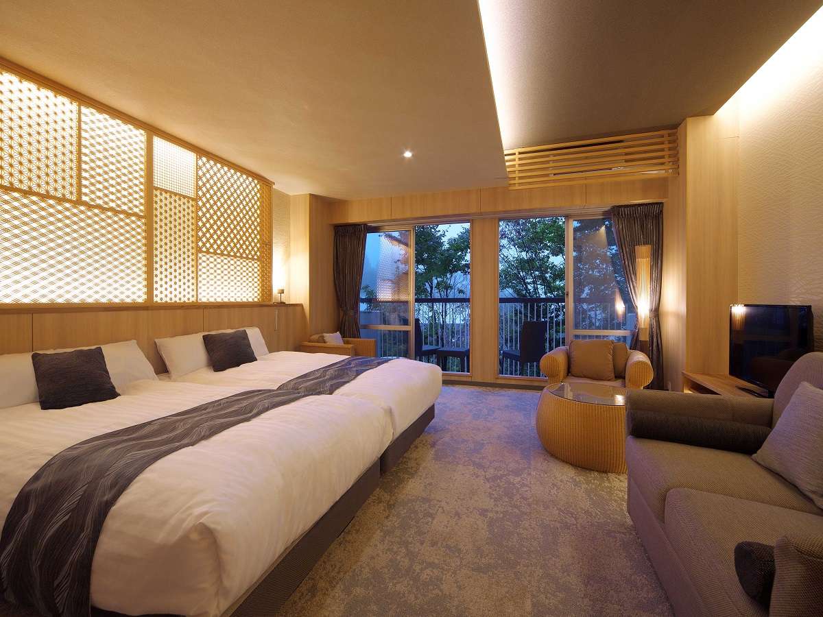 Japanese-modern twin room with backlit kumiko lattice screen and lounge seating at Hotel Spax Kusatsu