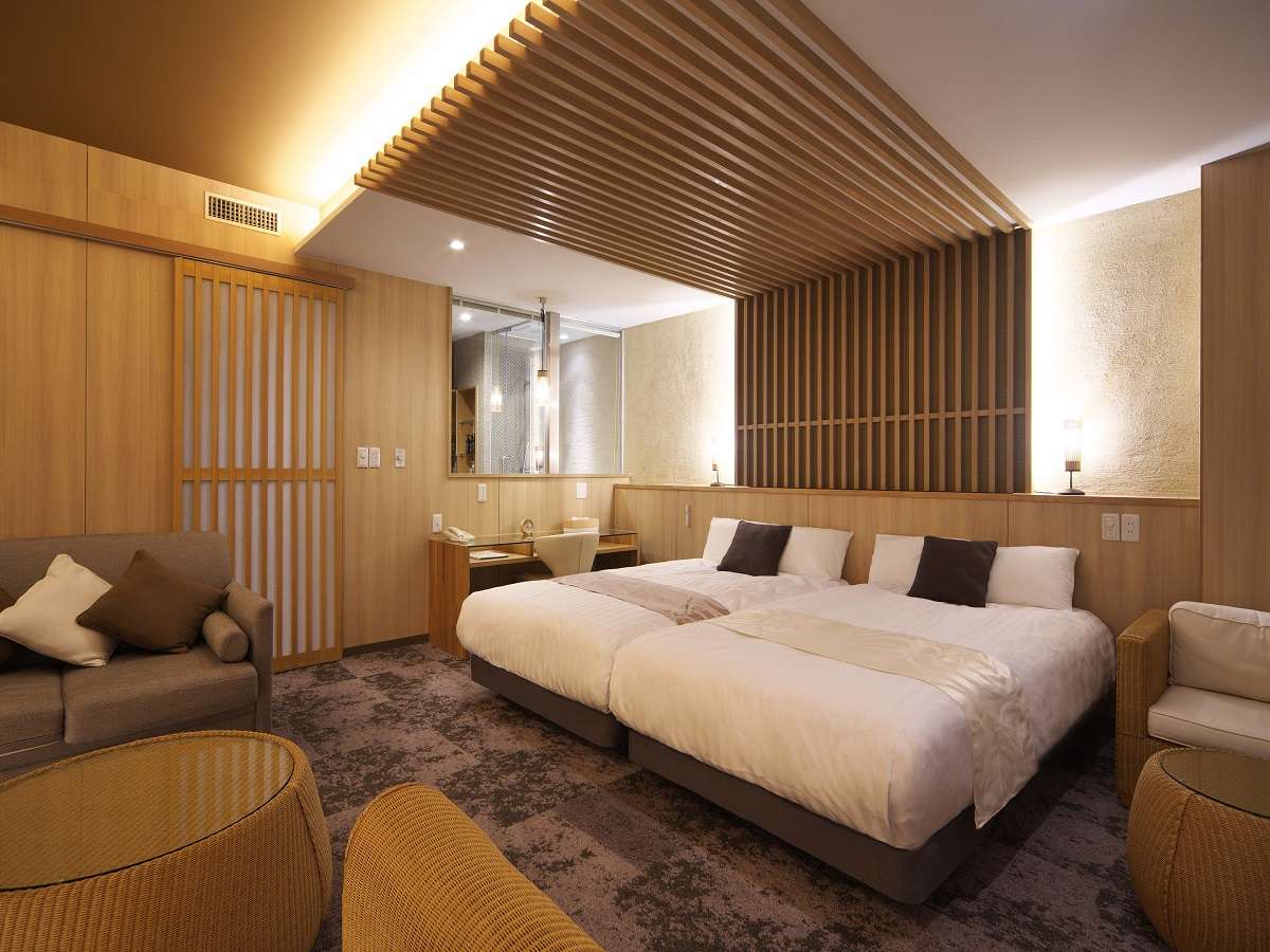 Warm wood-slatted ceiling twin room with sofa and rattan chairs at Hotel Spax Kusatsu
