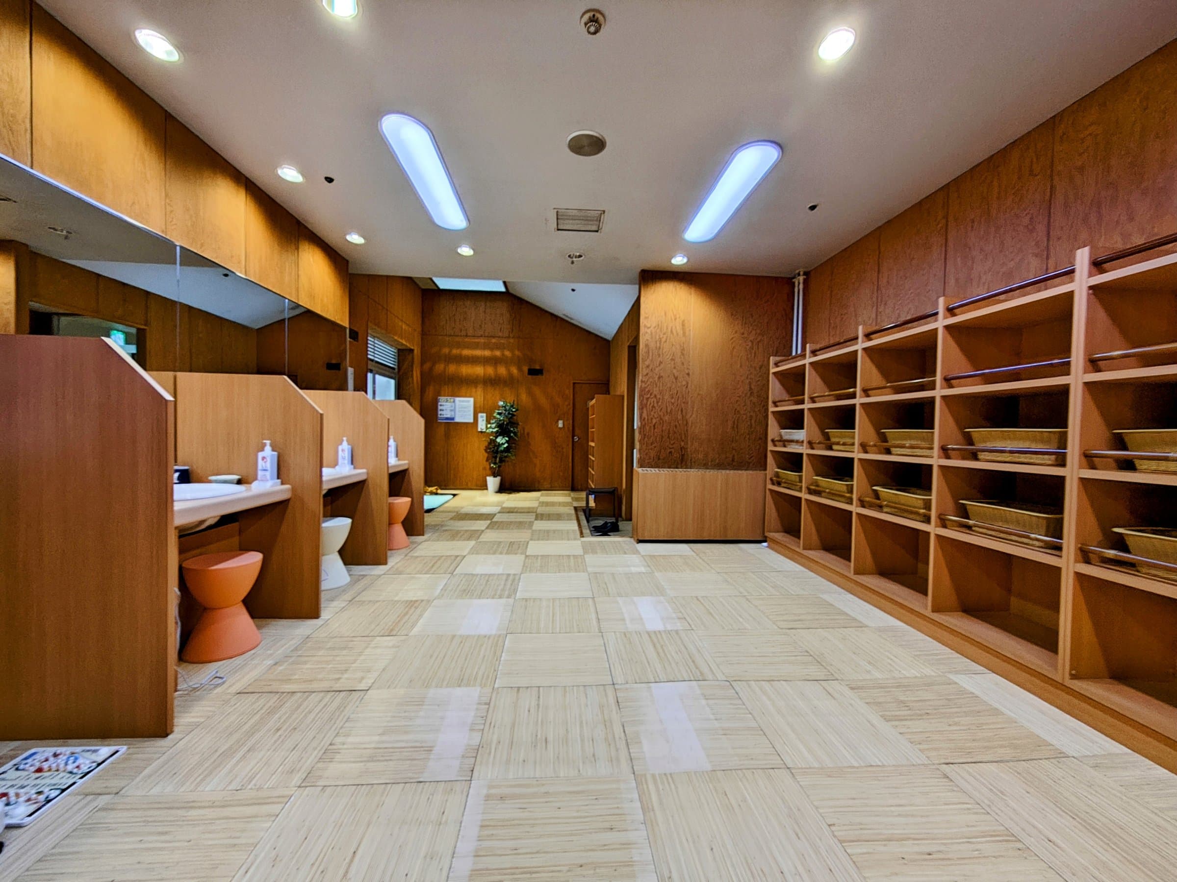 Bath powder room with wooden vanities, stools and yukata towel shelving at Hotel Spax Kusatsu