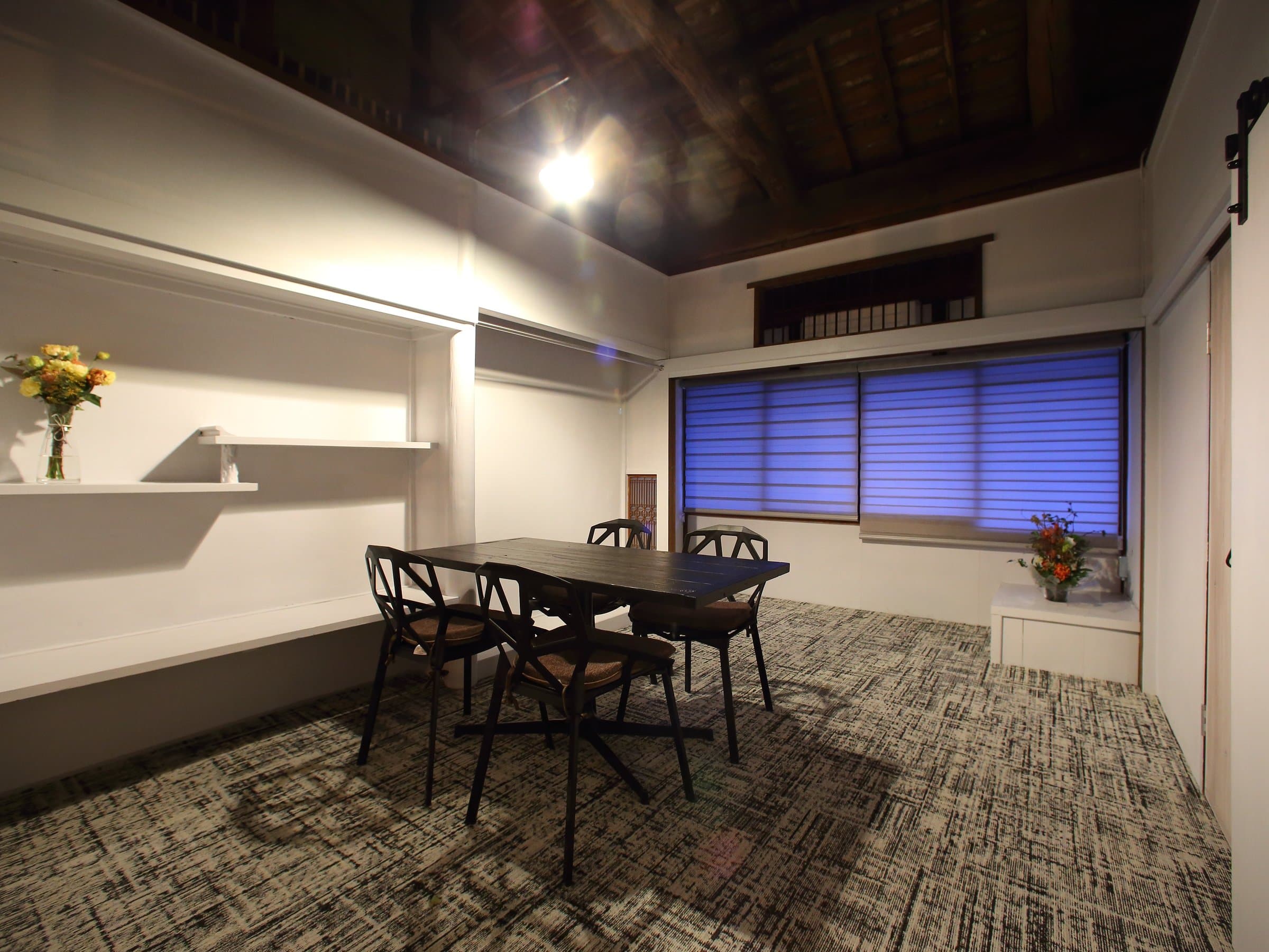 Bright twin futon guest room with warm wooden ceiling and bamboo-blind window at Hem's Hotel, Miyajima