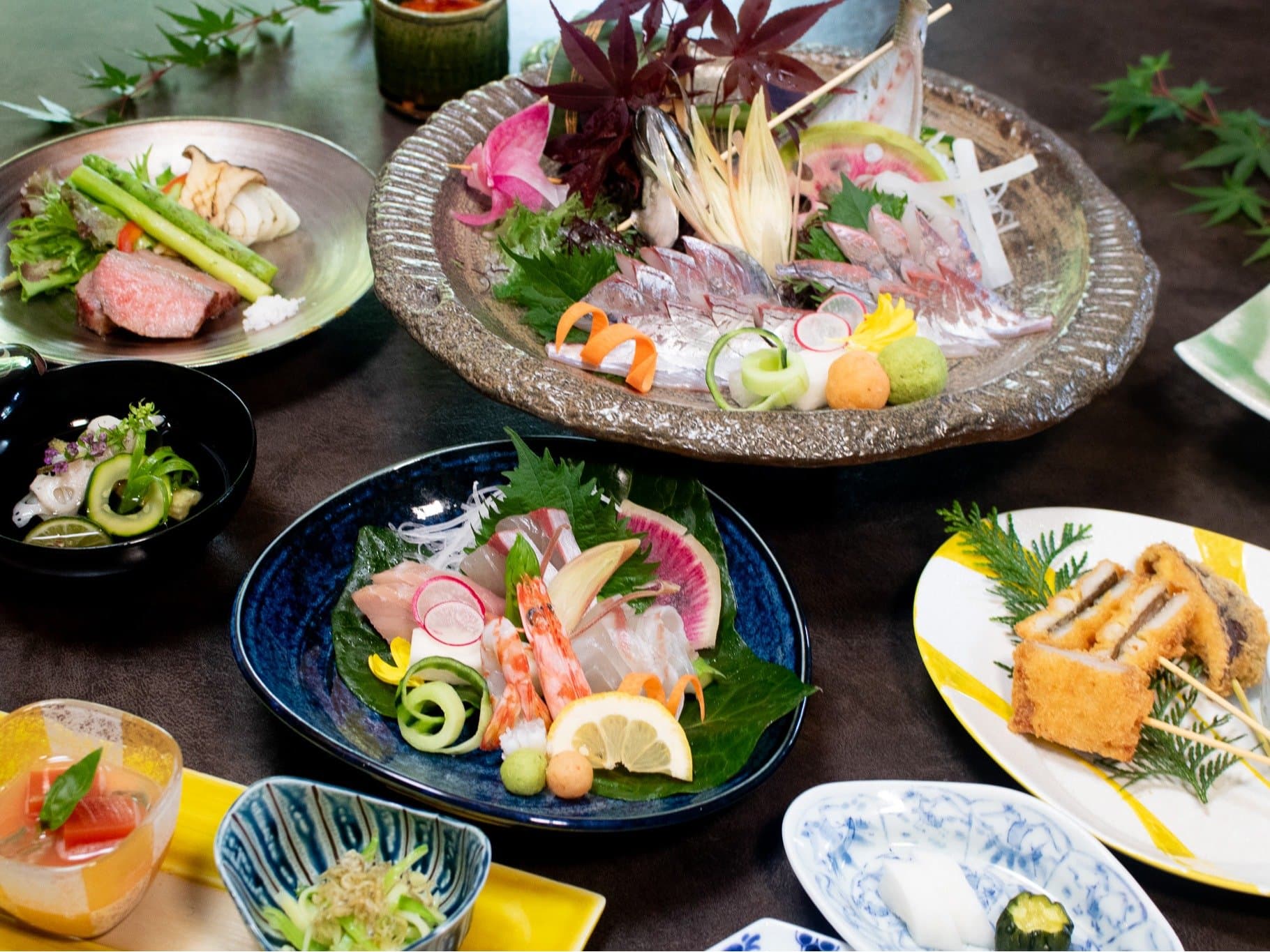 Kaiseki dinner spread with fresh sashimi platter, simmered dishes and seasonal garnishes on blue ceramics, Amane Resort GAHAMA, Beppu Onsen