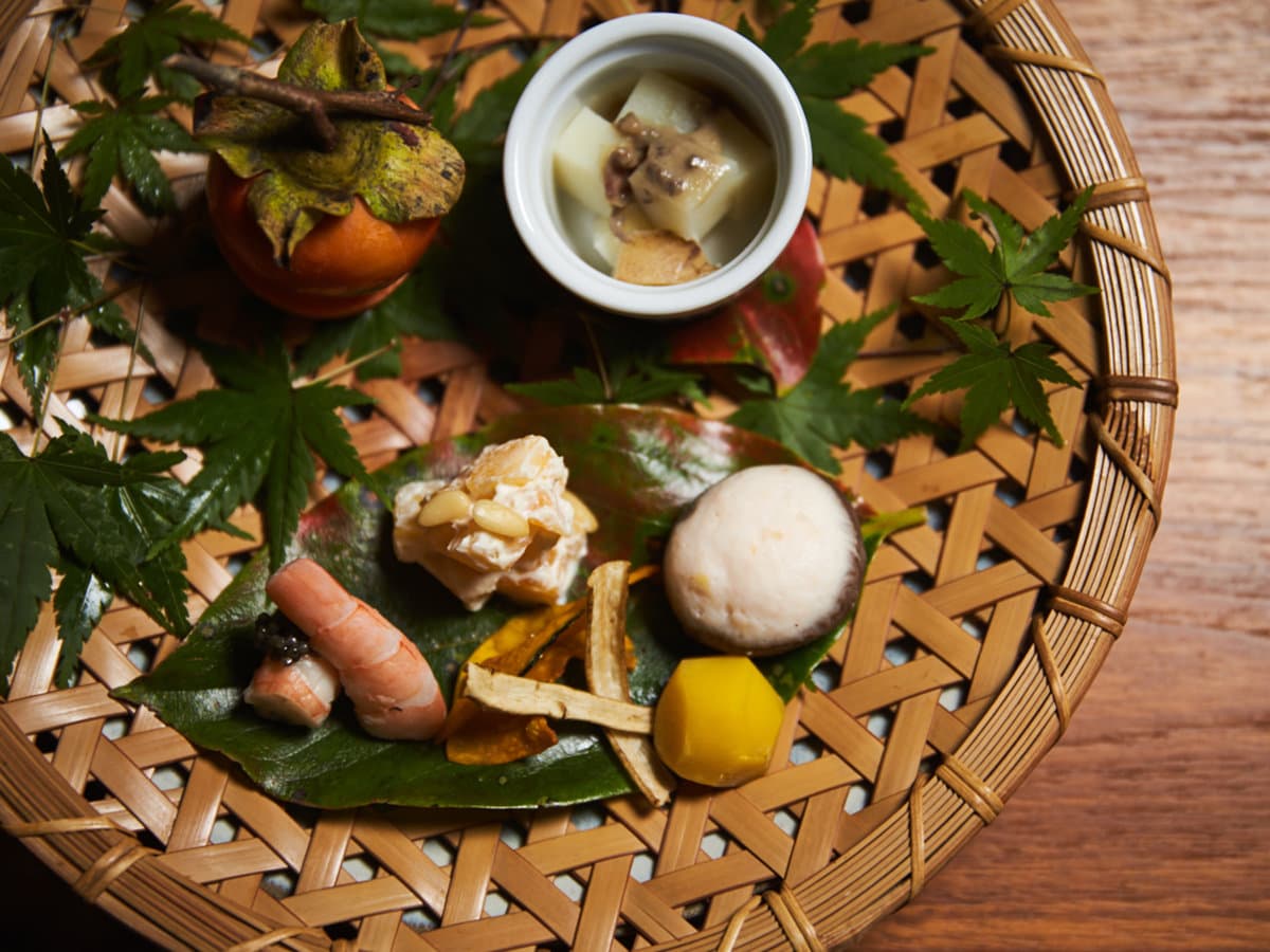 Kaiseki appetizer platter of seasonal small dishes on a woven bamboo basket at Sanso Warabino