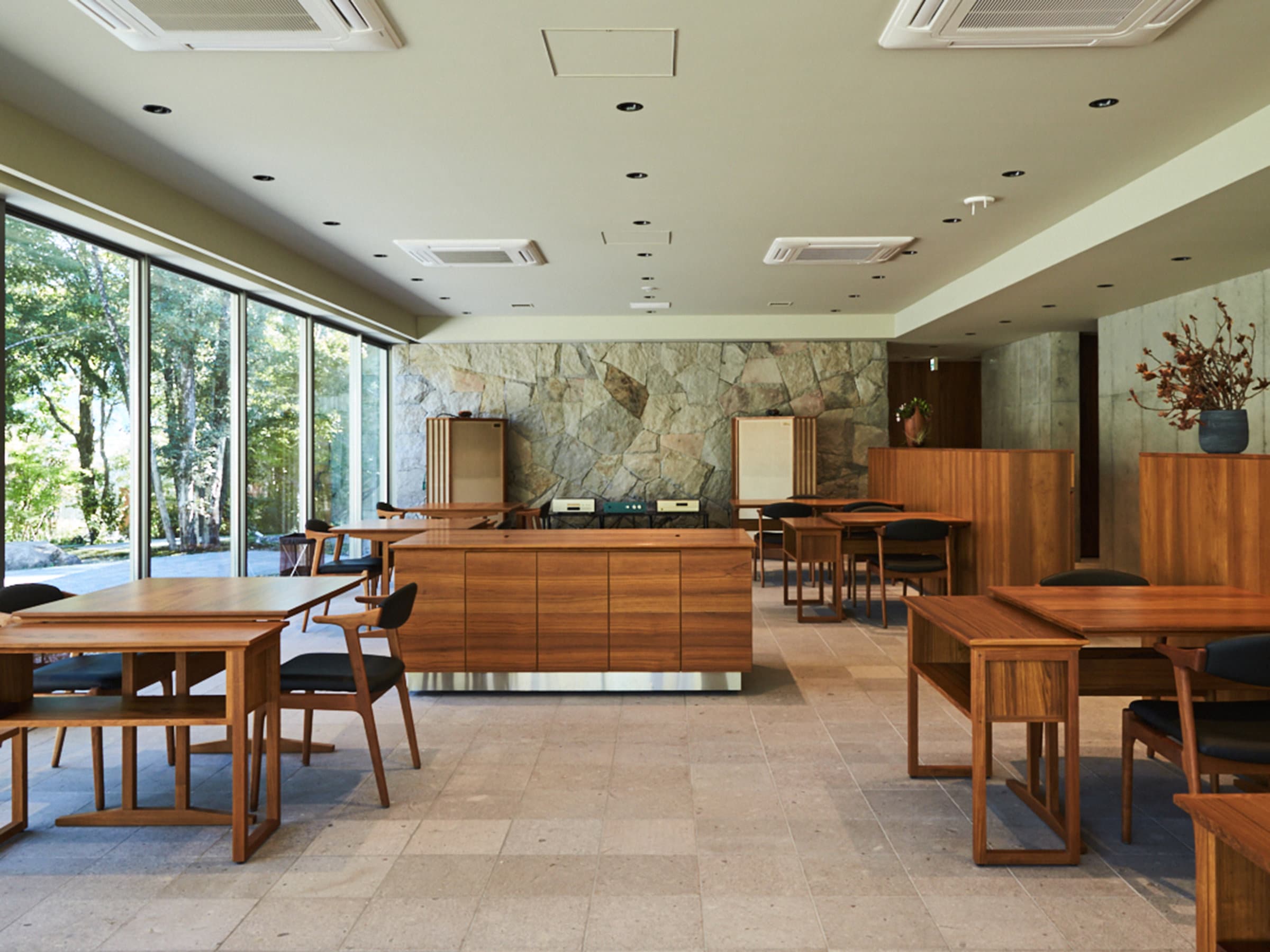 Lobby lounge and dining hall at Sanso Warabino with stone feature wall, walnut furniture and garden windows
