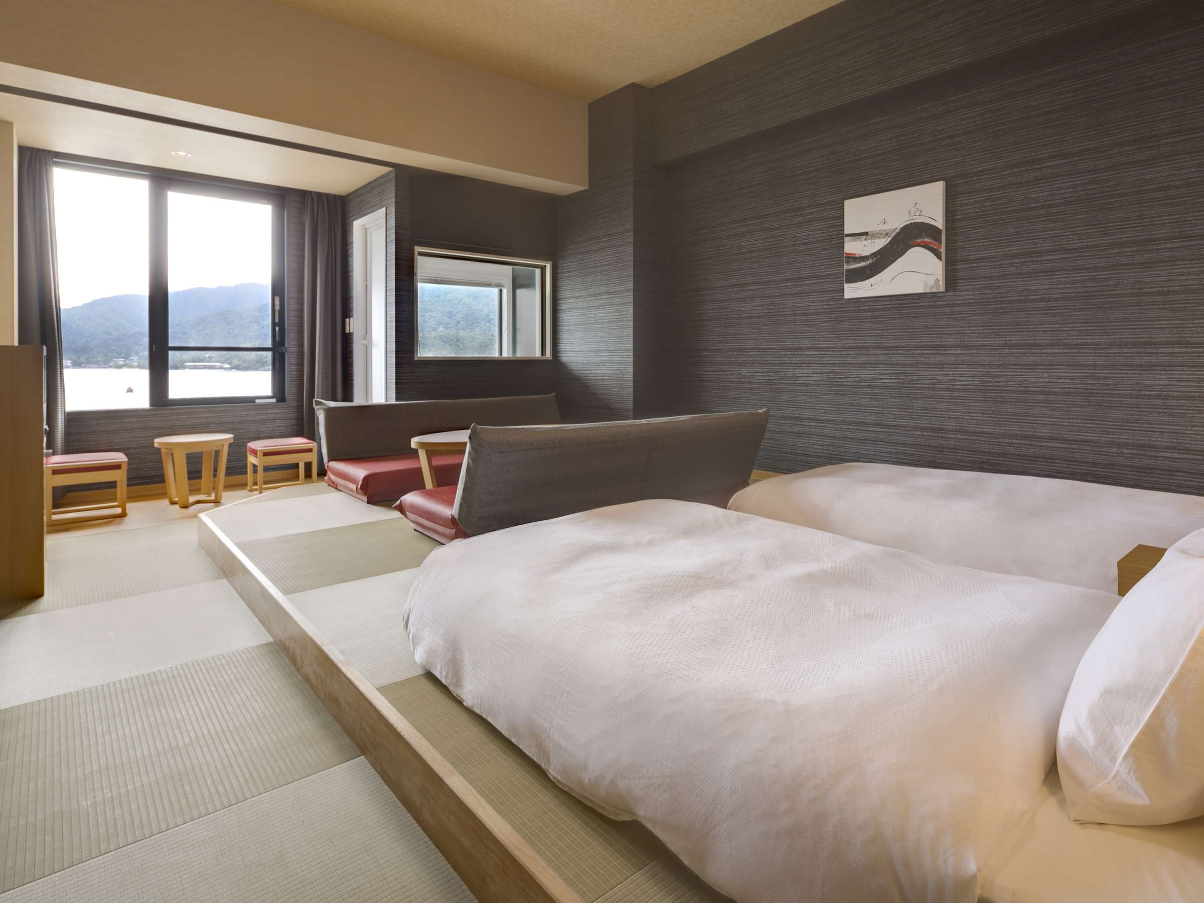 Executive twin guest room with tatami-edged floor and wide window framing the Seto Inland Sea and Miyajima