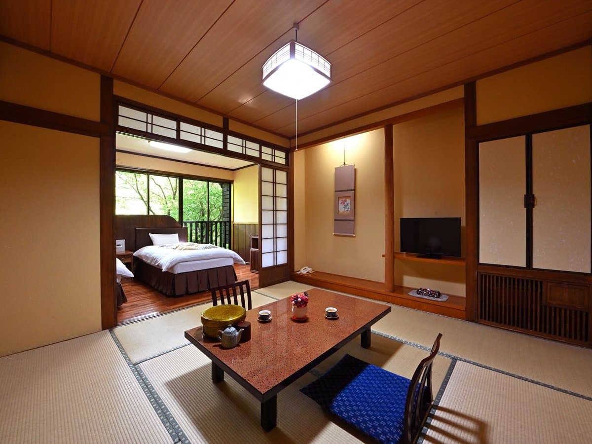 Tatami guest room with a low bed and tea table at Kiyashiki