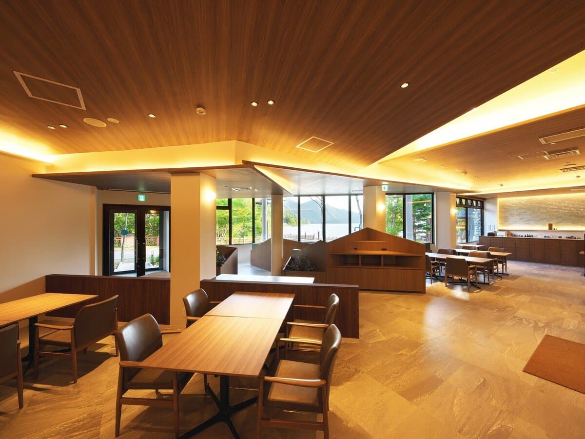 Spacious wood-toned dining hall with lake-facing windows at Hotel Hana-An in Chuzenji, Nikko