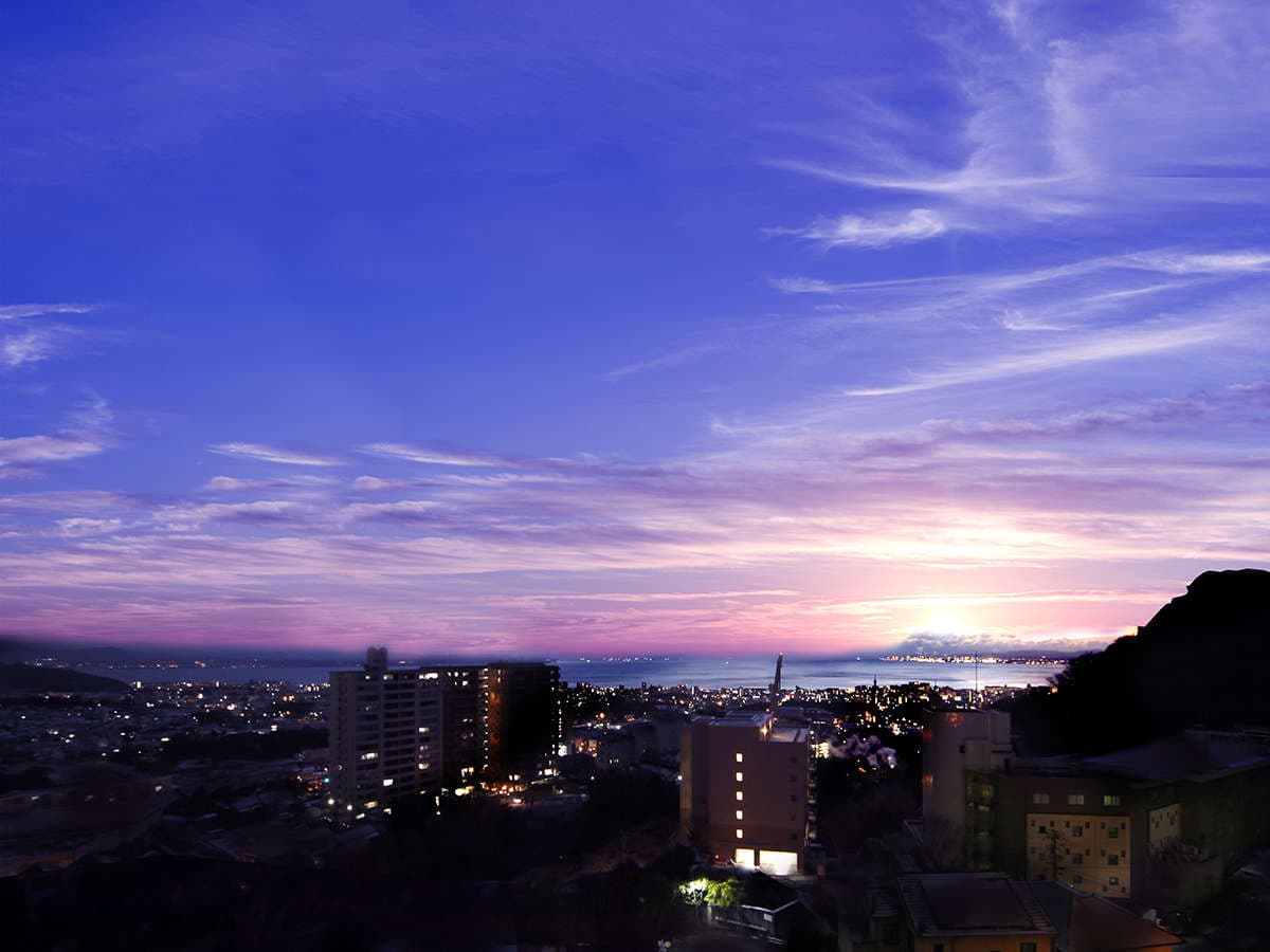 Sweeping dusk view over Beppu city lights and the bay under a pink and purple sunset sky, Ryotei Matsubaya, Beppu Onsen