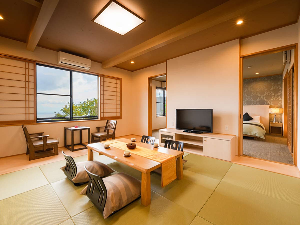 Spacious tatami guest room with low dining table, ocean-view window and an adjoining western-style bedroom, Ryotei Matsubaya, Beppu Onsen