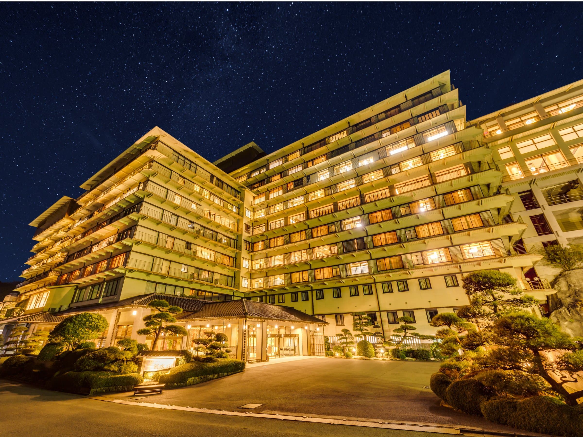Inatori Ginsuiso ryokan exterior illuminated at night under a starry sky in Inatori Onsen, Izu