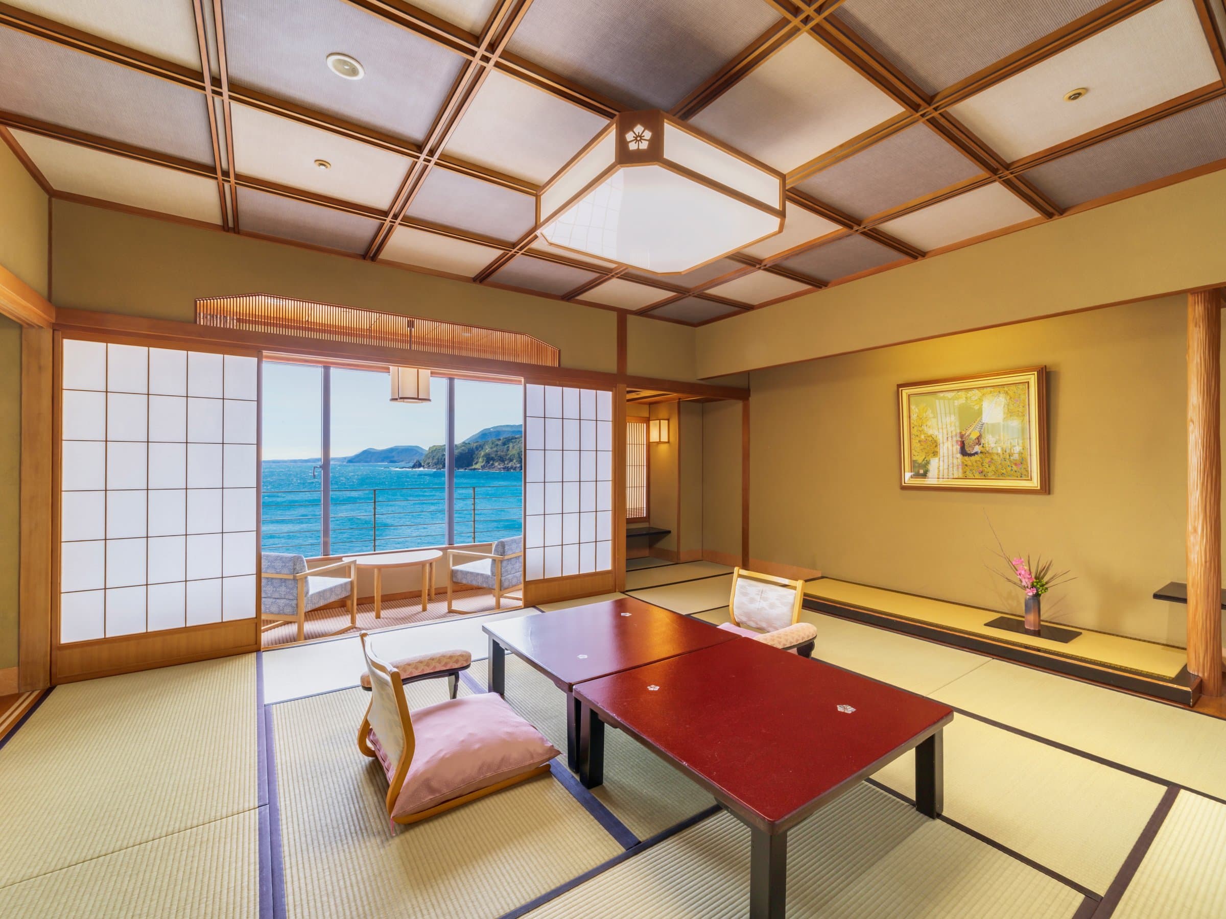Traditional tatami guest room with low table and ocean view at Inatori Ginsuiso, Izu