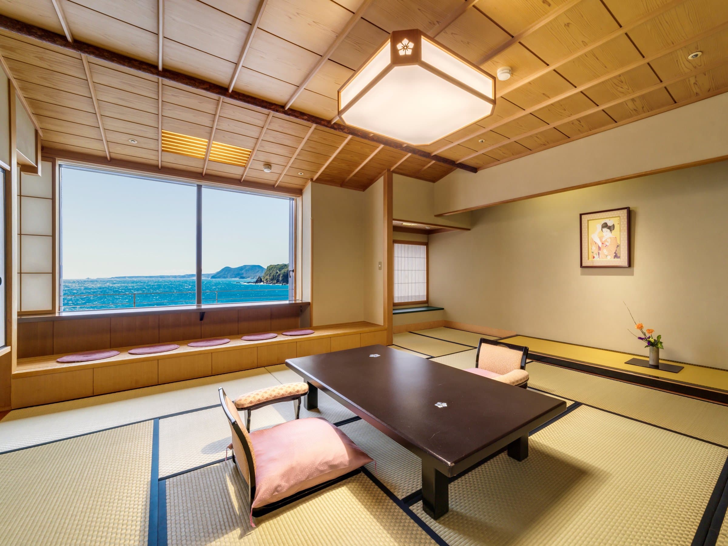 Bright Japanese-style tatami room with panoramic sea view and window bench at Inatori Ginsuiso