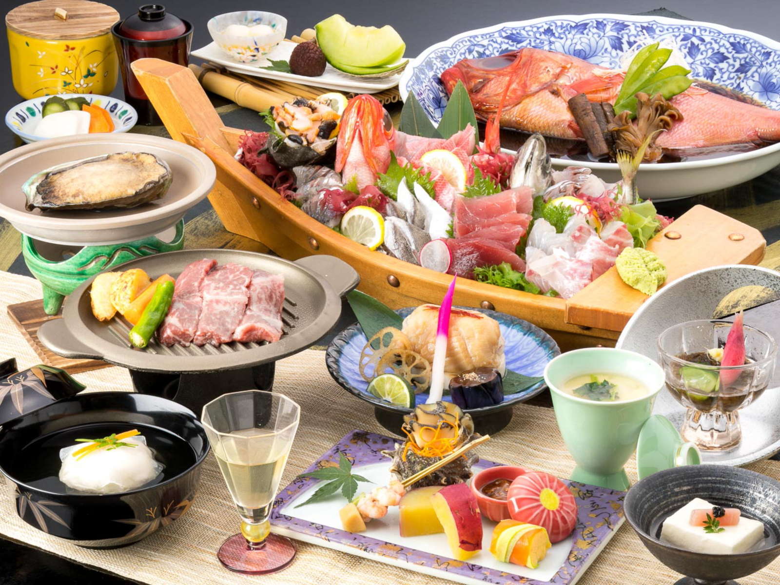 Kaiseki dinner spread with sashimi boat and seafood dishes at Hotel Kanichi