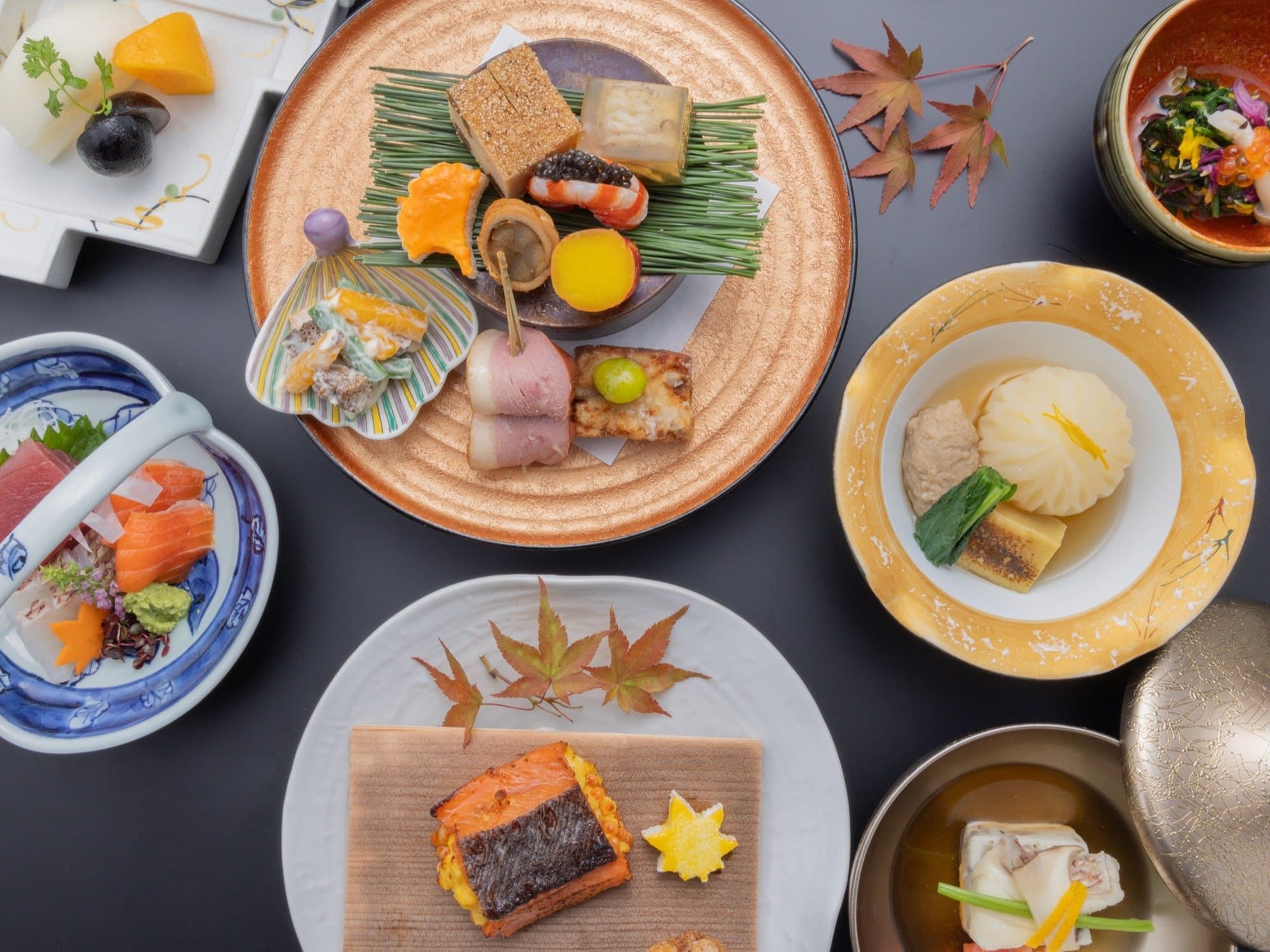 Multi-course kaiseki dinner spread with sashimi, assorted appetizers and grilled fish at Kanemidori