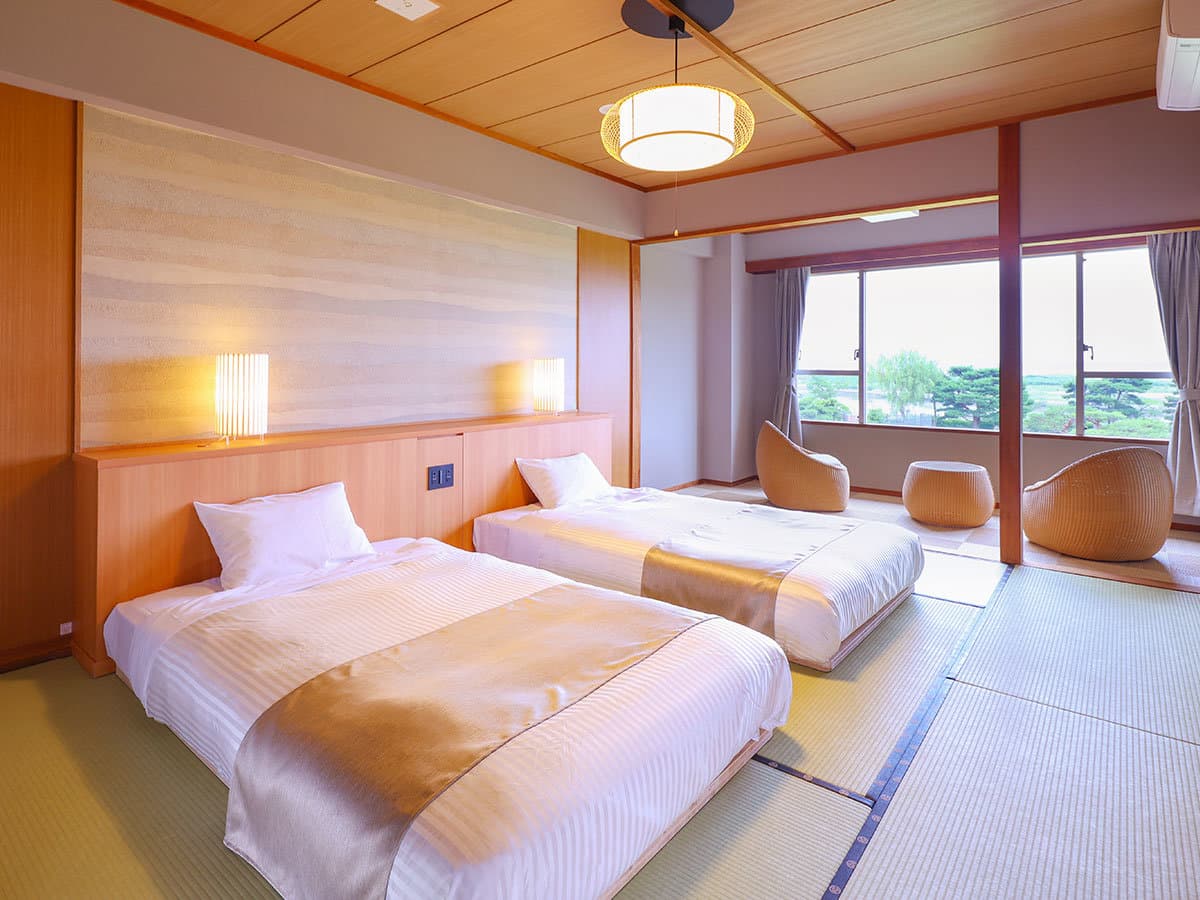 Japanese-Western twin room with tatami flooring, low beds and rattan chairs overlooking the valley