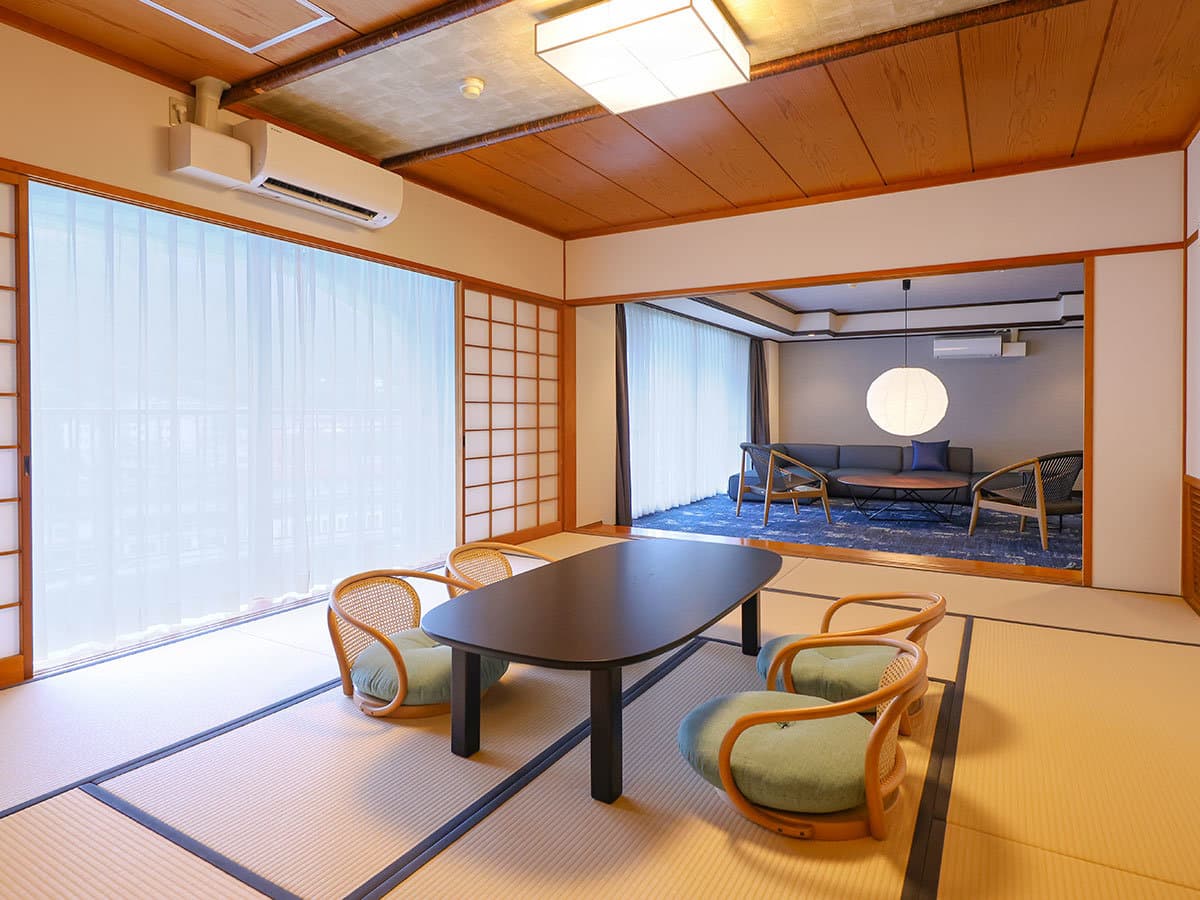 Premium suite guest room with a tatami living space, low table and adjoining lounge area