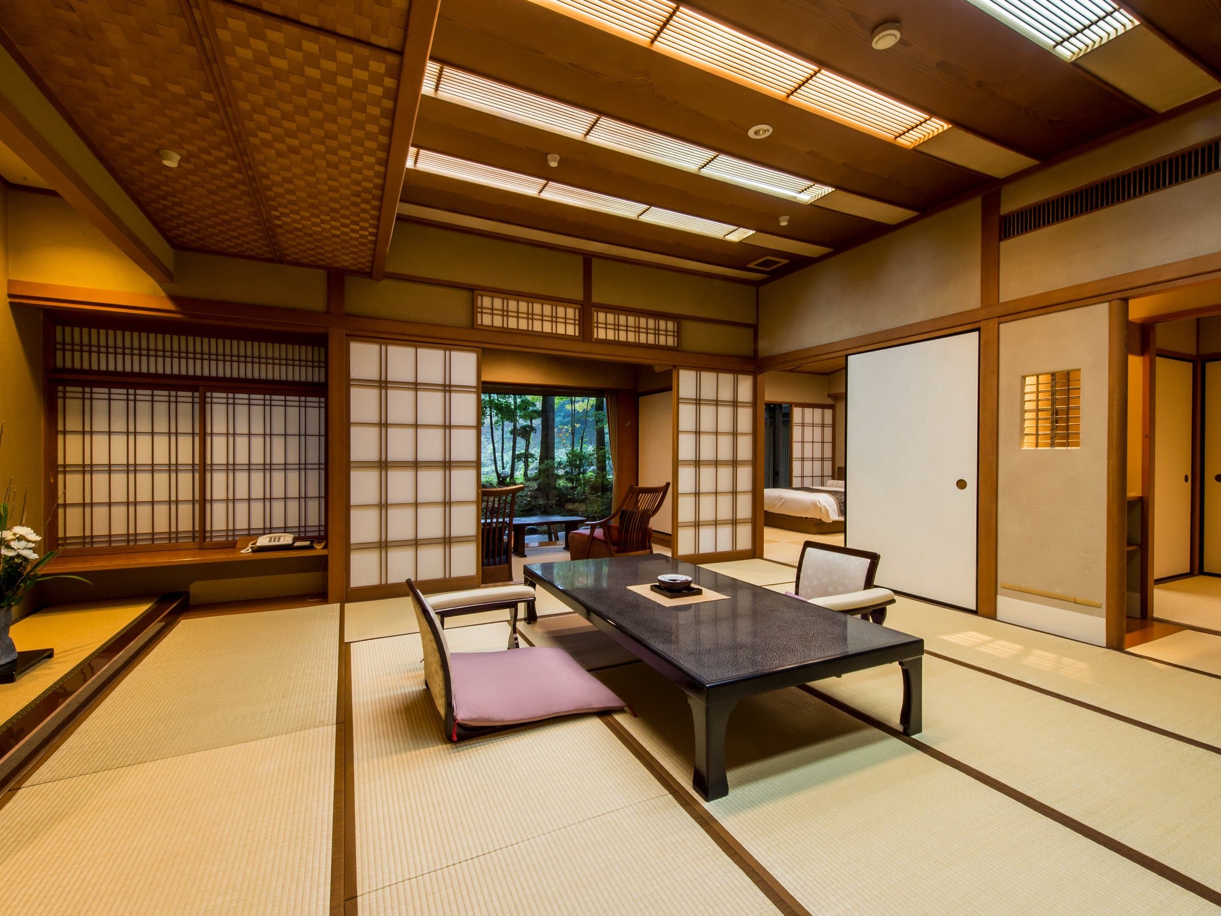 Bright tatami guest room with shoji screens opening to a garden veranda at Sagasawakan in Izu