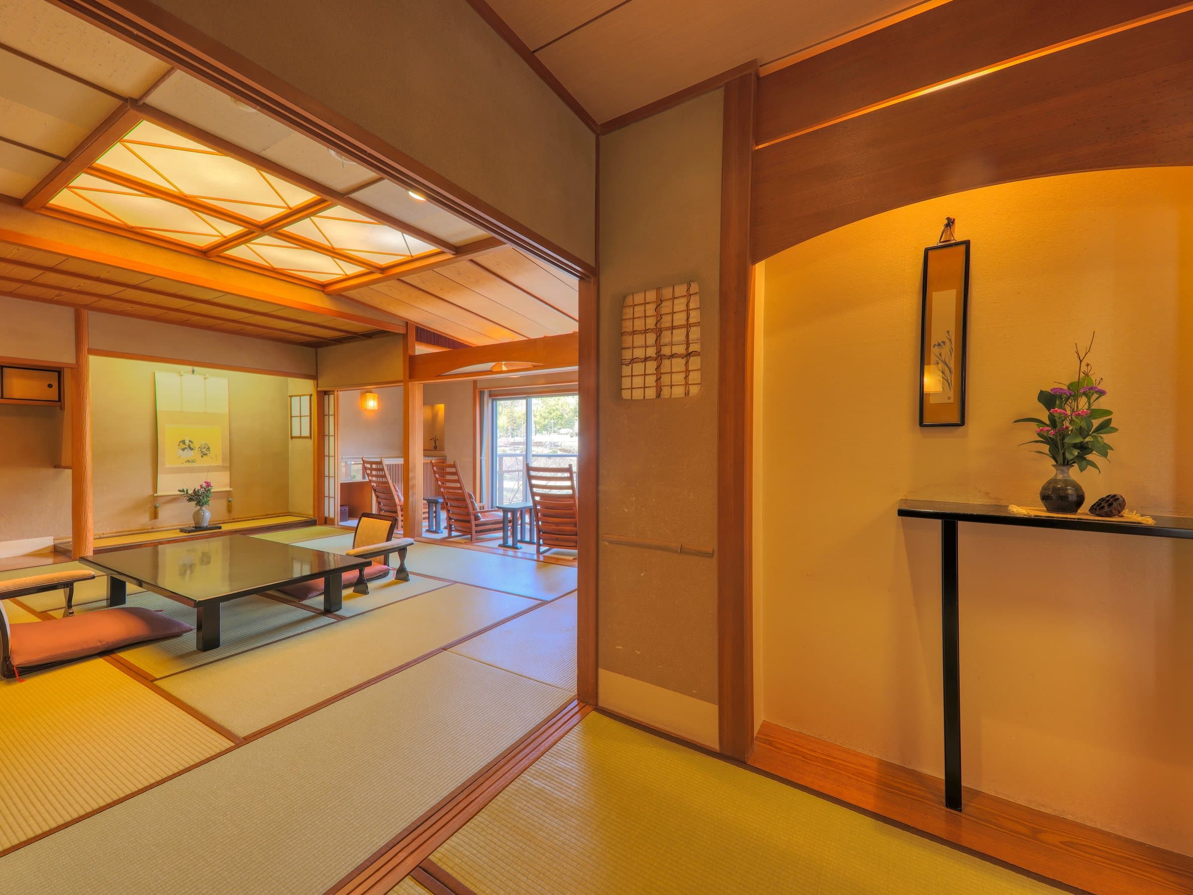 Spacious tatami guest room with a tokonoma alcove and flower arrangement at Sagasawakan ryokan, Izu