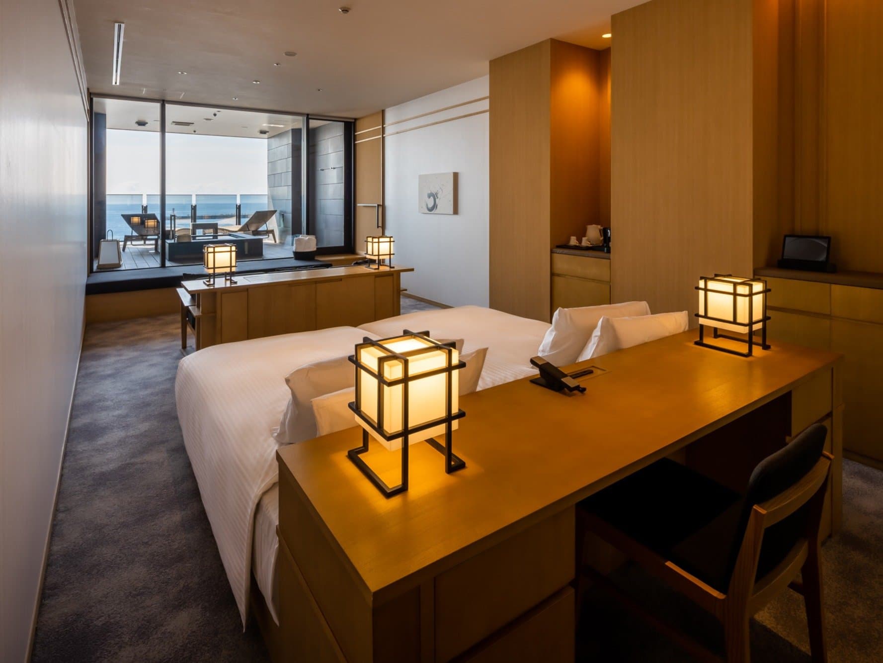 Guest room with twin beds, lantern lighting and private sea-view terrace at Pearl Star Hotel Atami