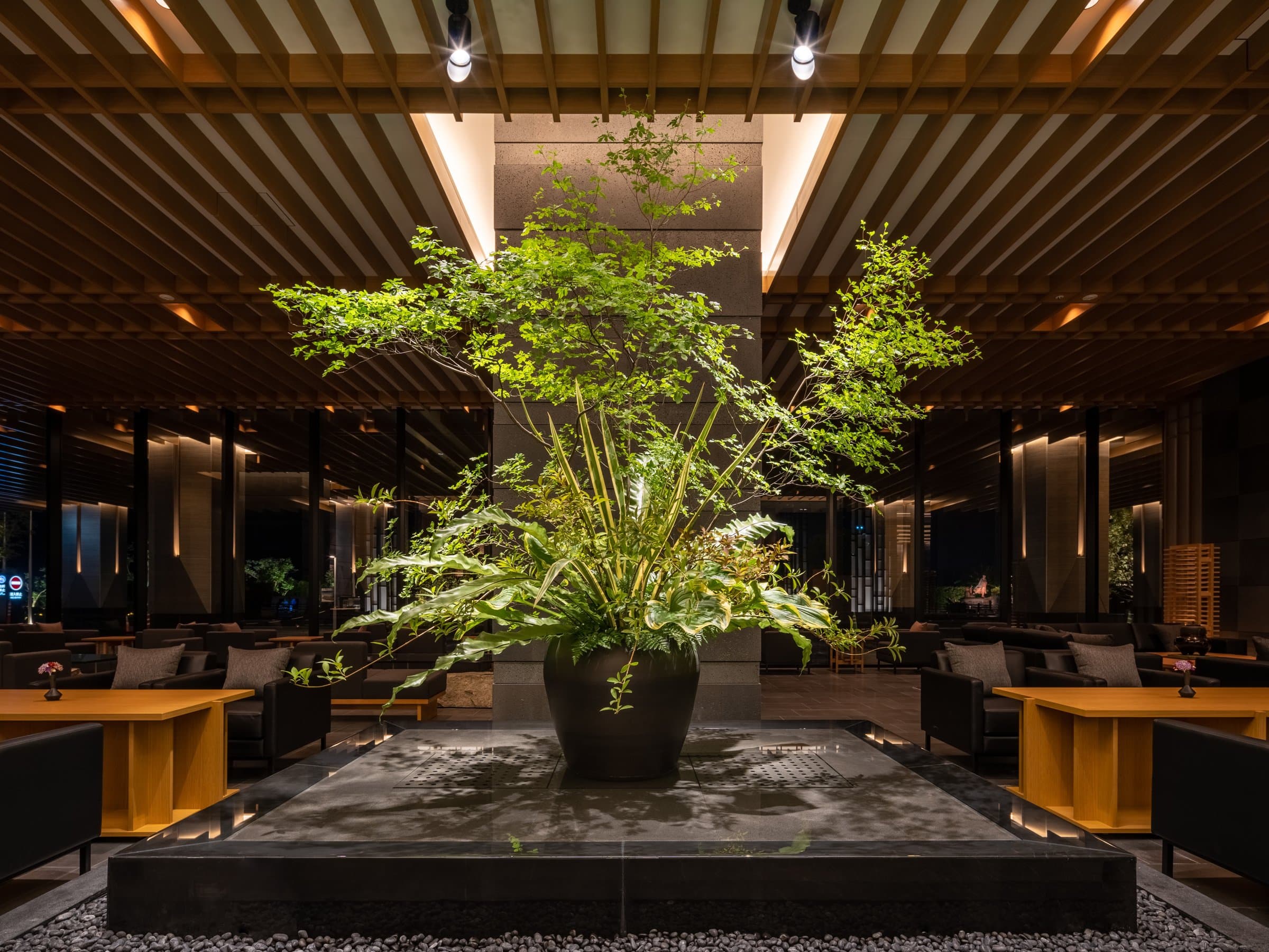Warm wood lobby lounge with a large green plant centerpiece at Pearl Star Hotel Atami