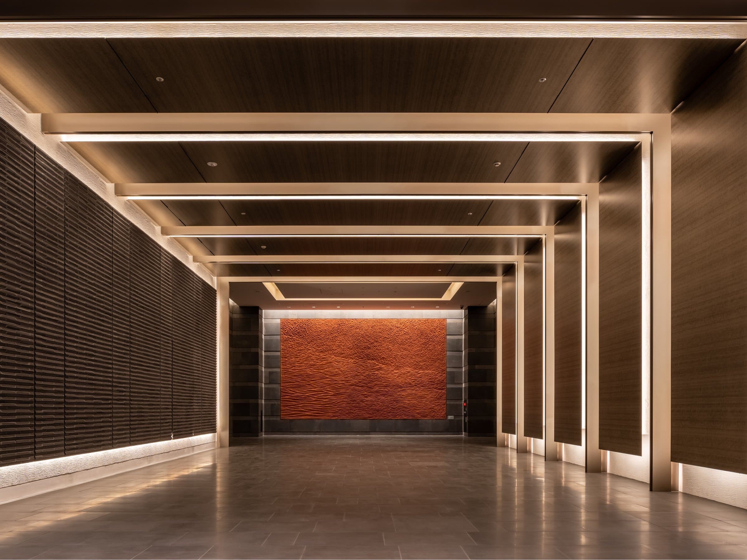 Entrance corridor with timber-framed ceiling and copper art wall at Pearl Star Hotel Atami