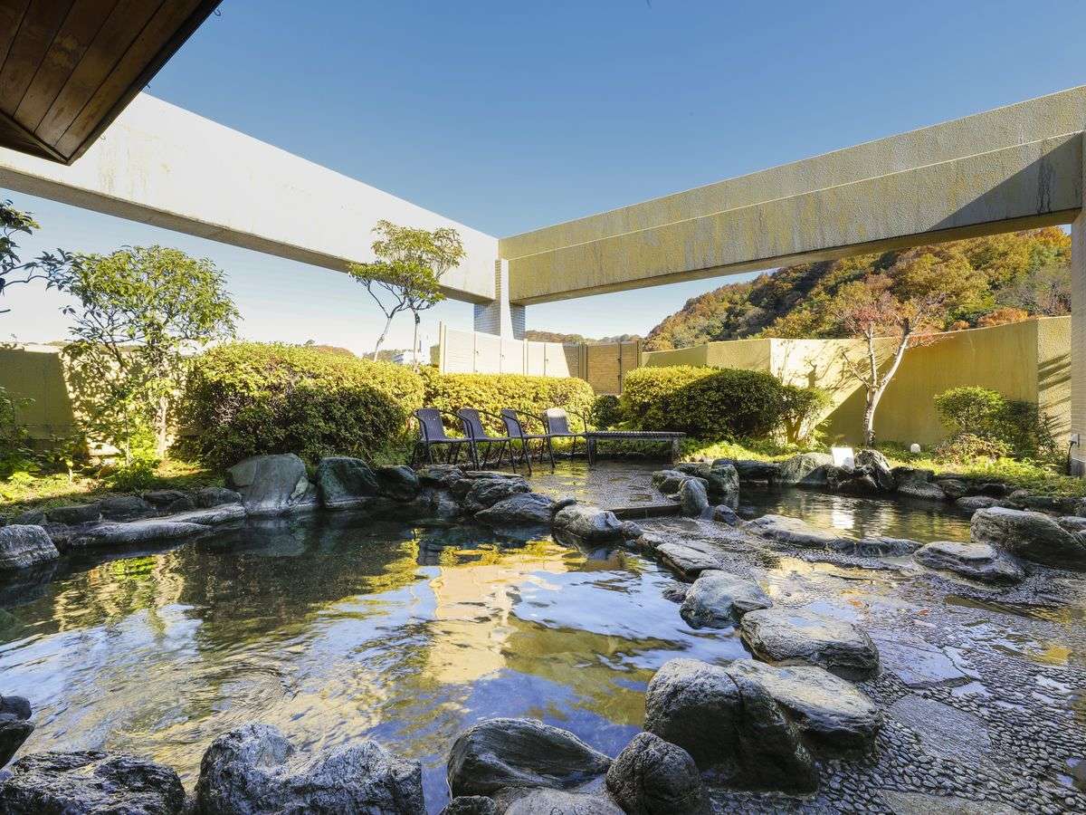 Open-air rock rotenburo bath overlooking autumn hills at Hotel Katsuragi, Dogo Onsen
