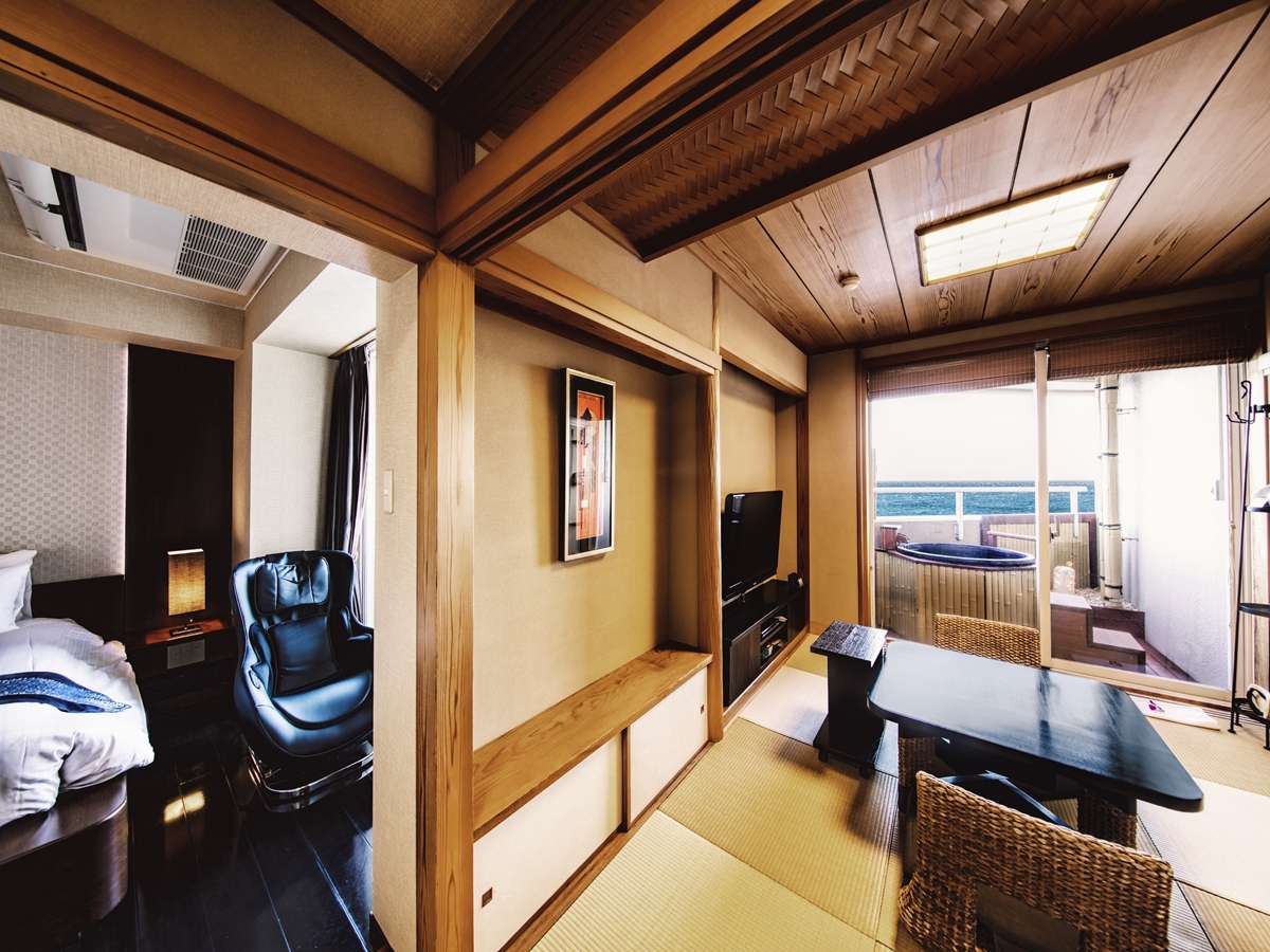 Japanese-Western guest room with tatami, bed and a private balcony open-air tub facing the Izu coastline at dusk