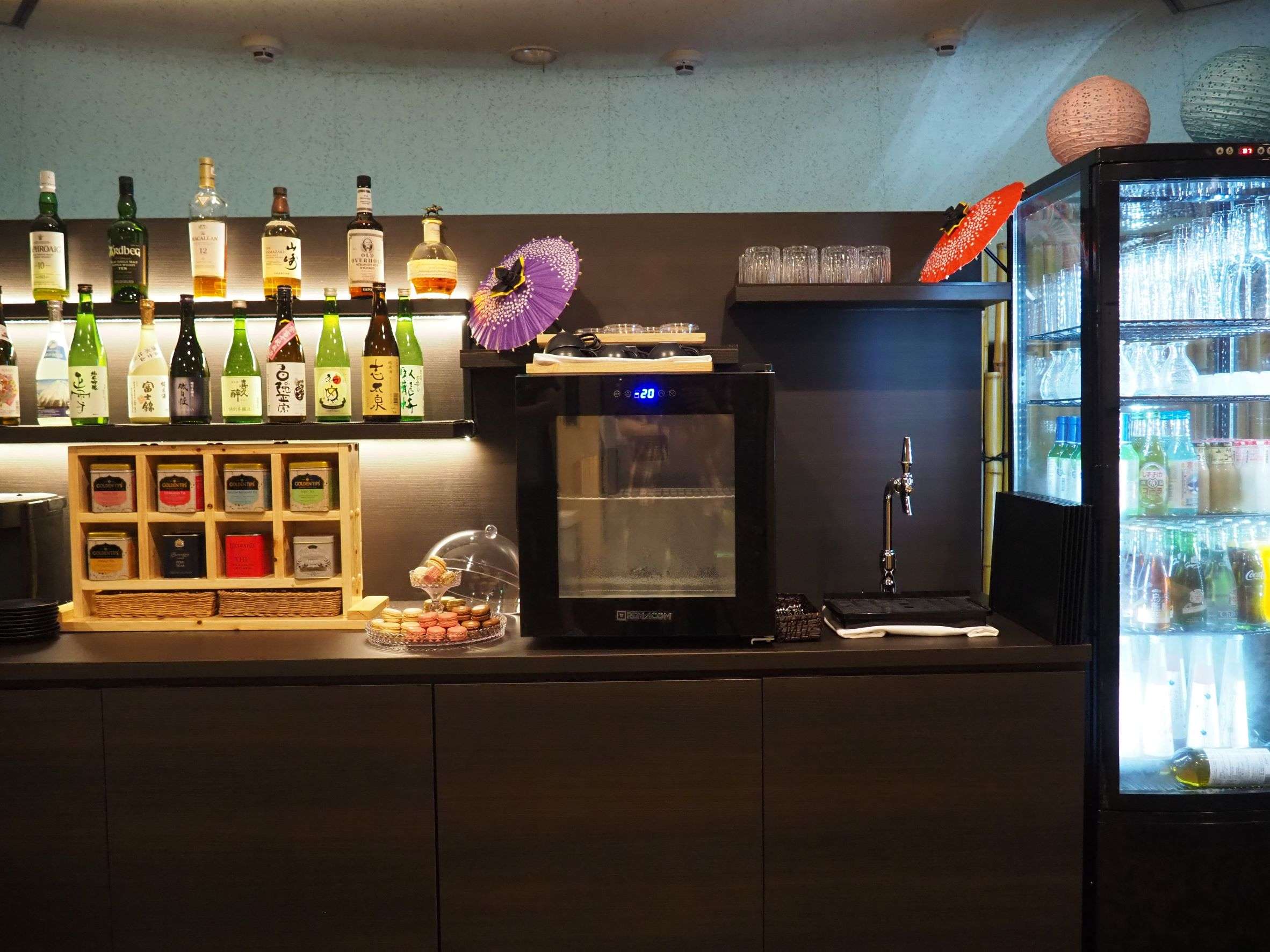 Lounge bar counter with local sake bottles and sweets at Kaze no Kaori UMI in Izu