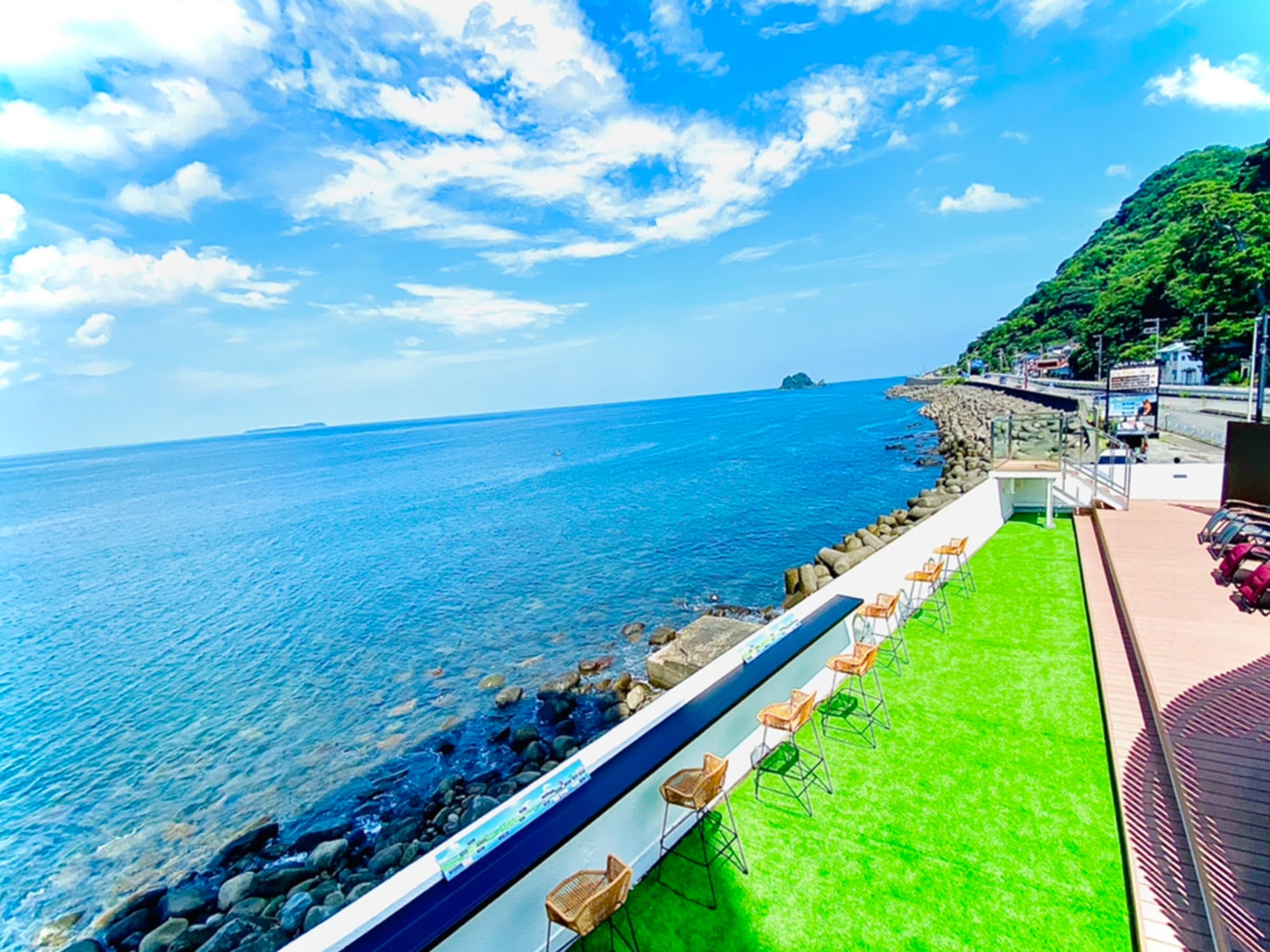Oceanfront rooftop terrace with lawn and lounge seating overlooking Suruga Bay at LUXURY Wa Hotel Kaze no Kaori UMI in Izu