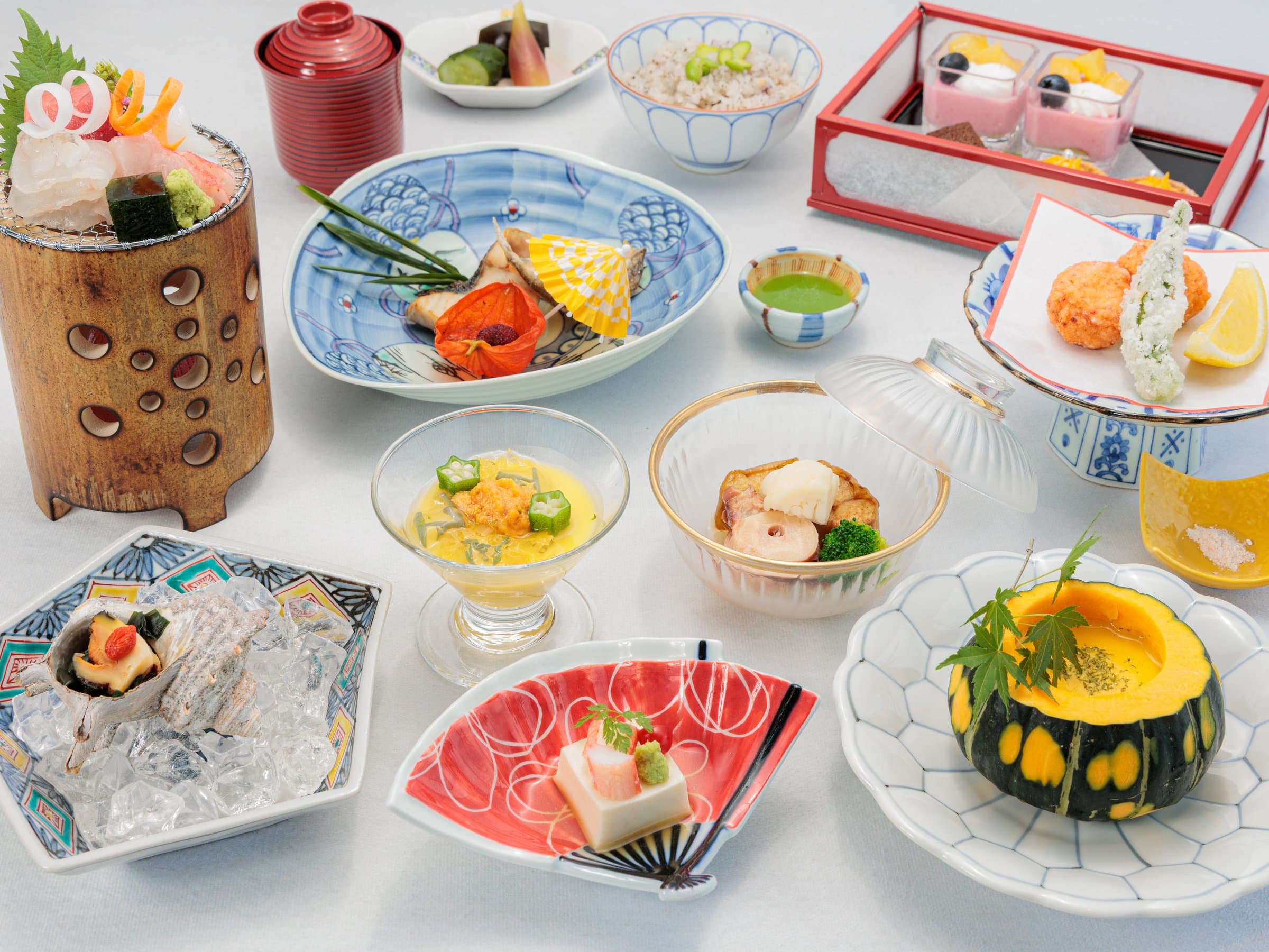 Multi-course kaiseki dinner spread with sashimi, simmered dishes and seasonal small plates