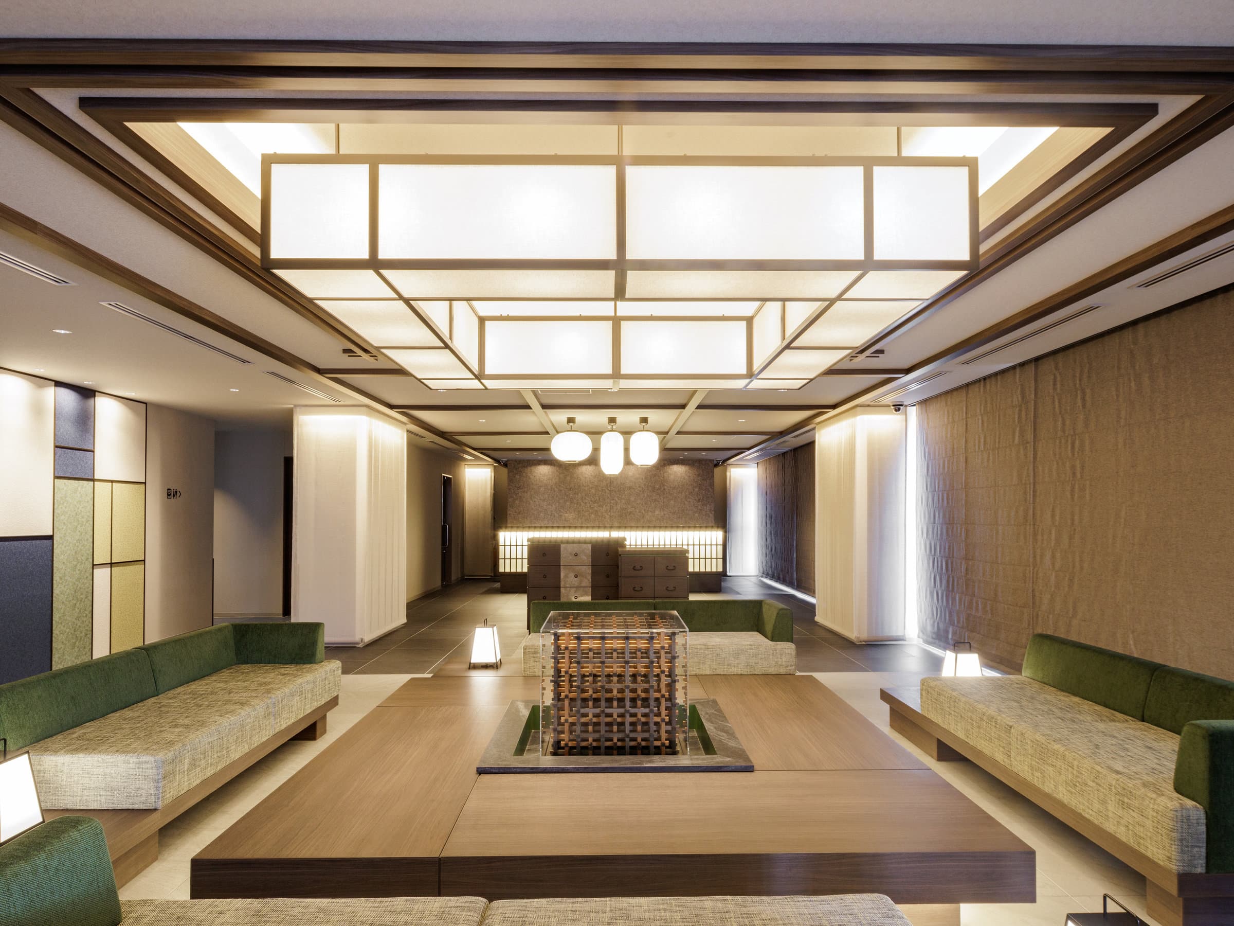 Lobby lounge with large washi paper ceiling lantern and green sofas at HOTEL AMANEK Hida Takayama