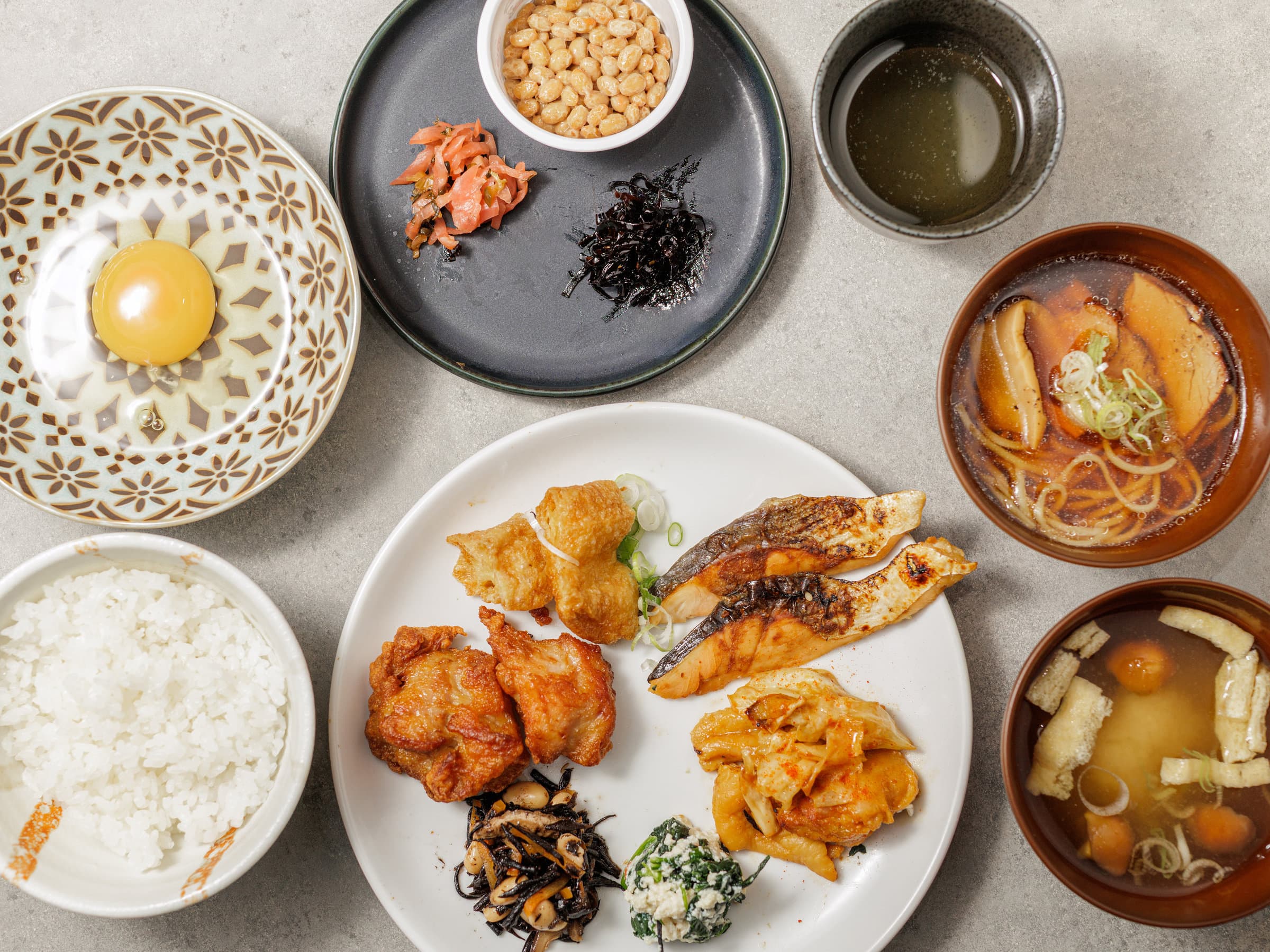 Japanese breakfast set with rice, raw egg, grilled fish, natto and miso soup