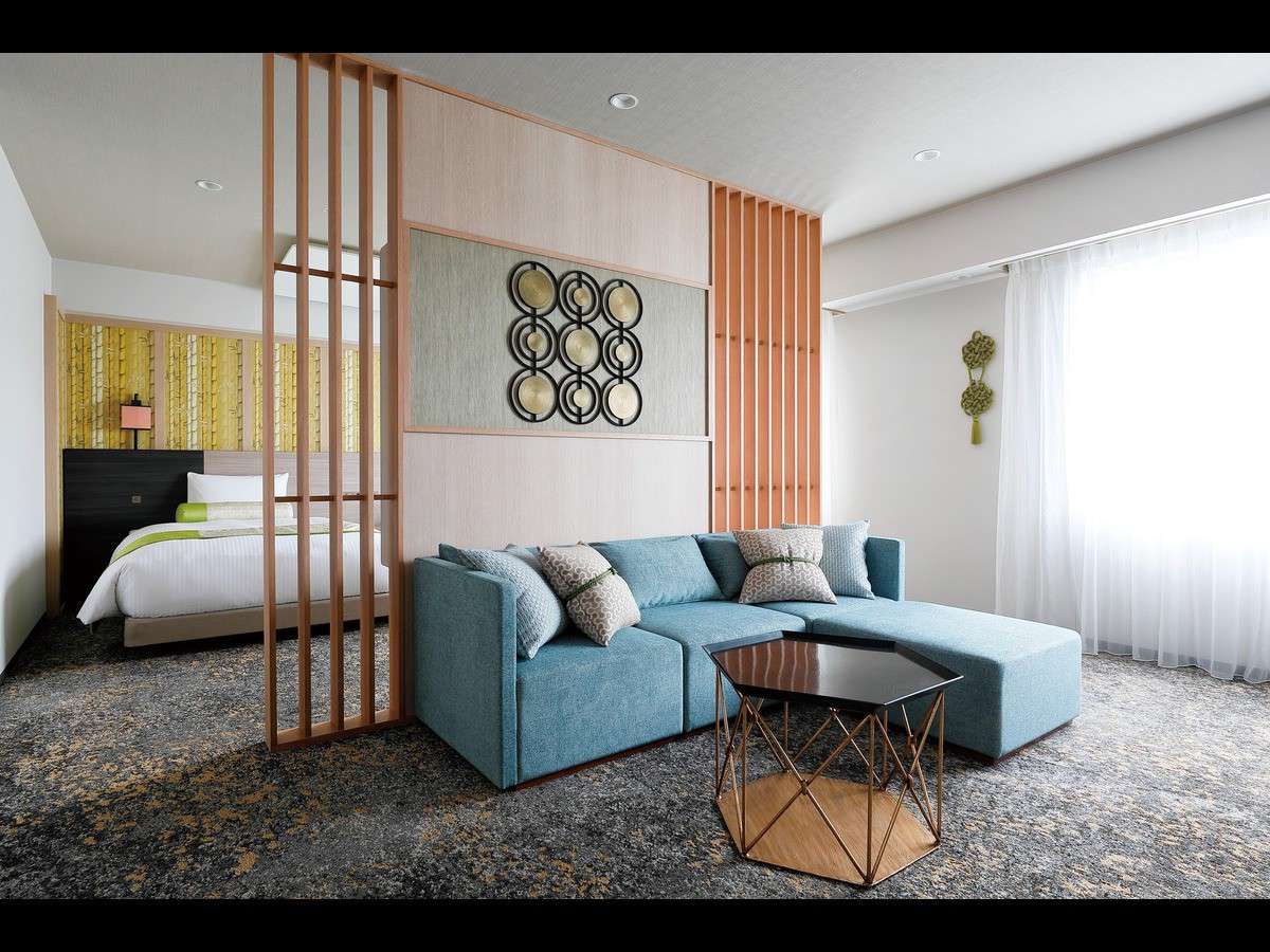 Suite room with a separated bed alcove and a blue sofa lounge area at Daiwa Roynet Hotel Nara