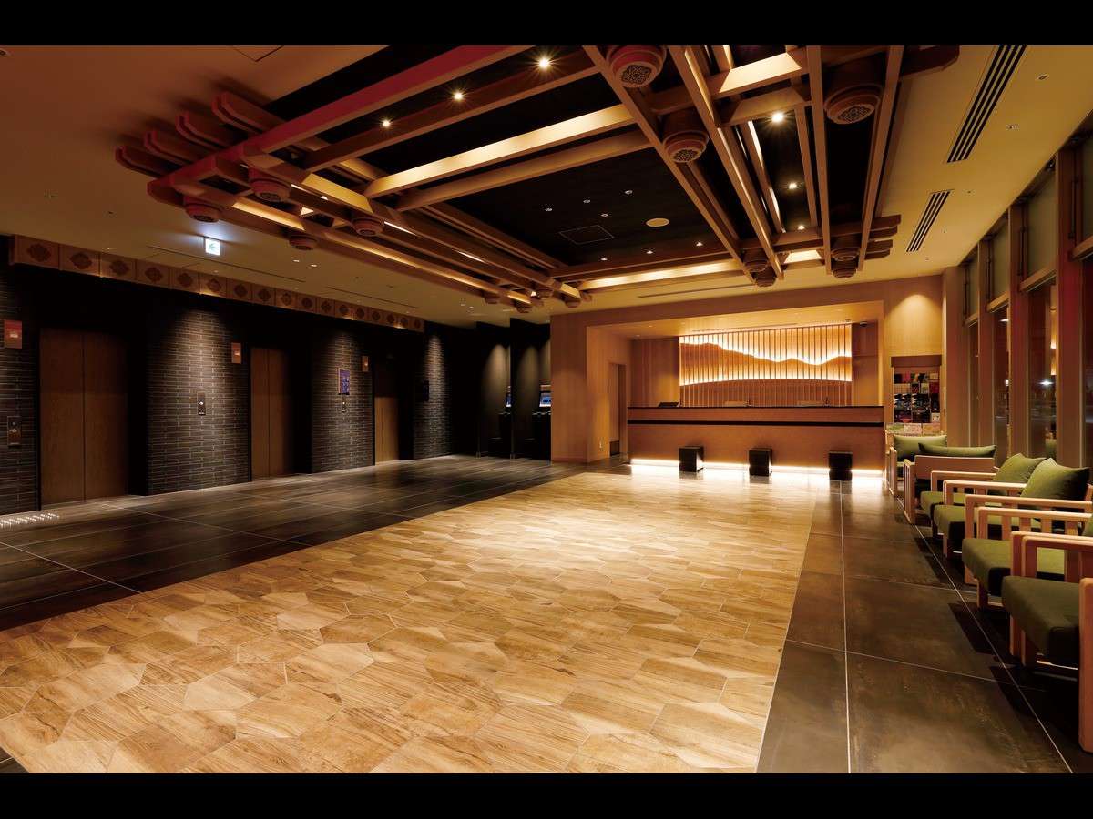 Spacious lobby with a coffered timber ceiling, stone floor and green lounge seating at Daiwa Roynet Hotel Nara