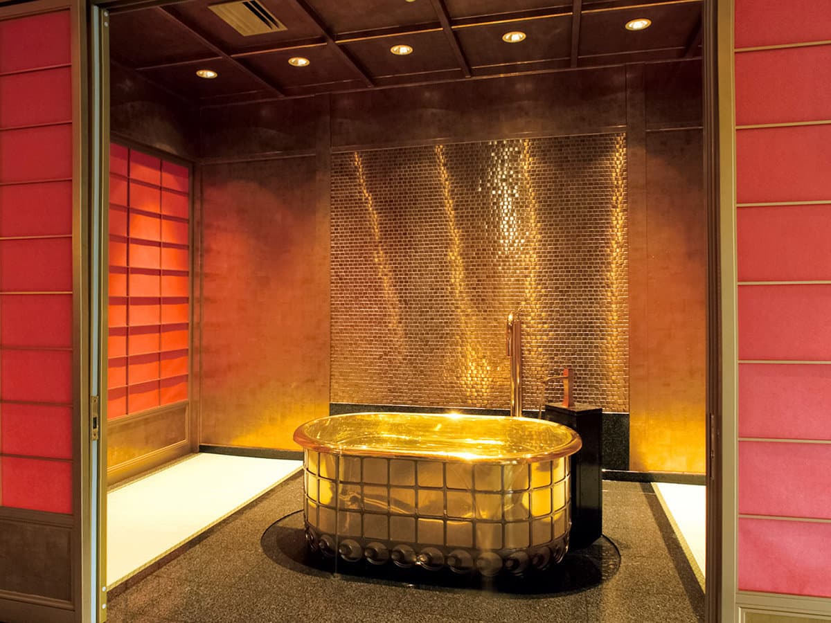 Signature golden bath in a warm copper-toned private bathing room with shoji screens at Mikazuki