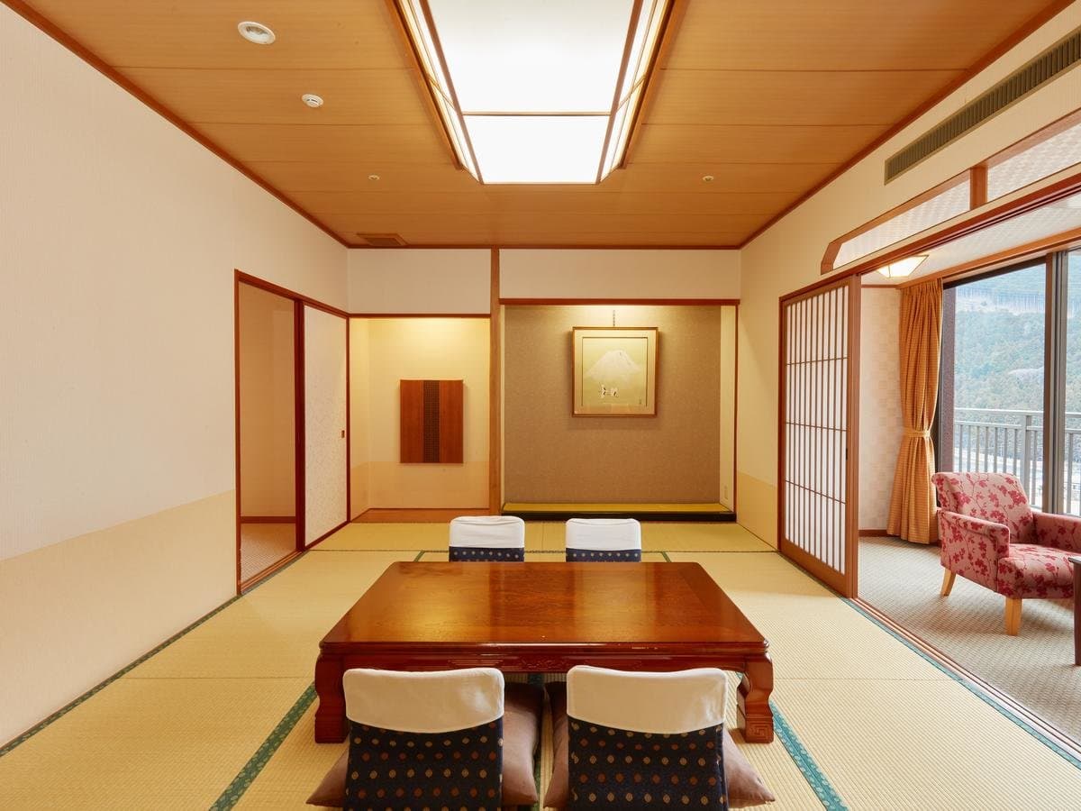 Traditional tatami guest room with tokonoma alcove, low table and a mountain-view window at Mikazuki
