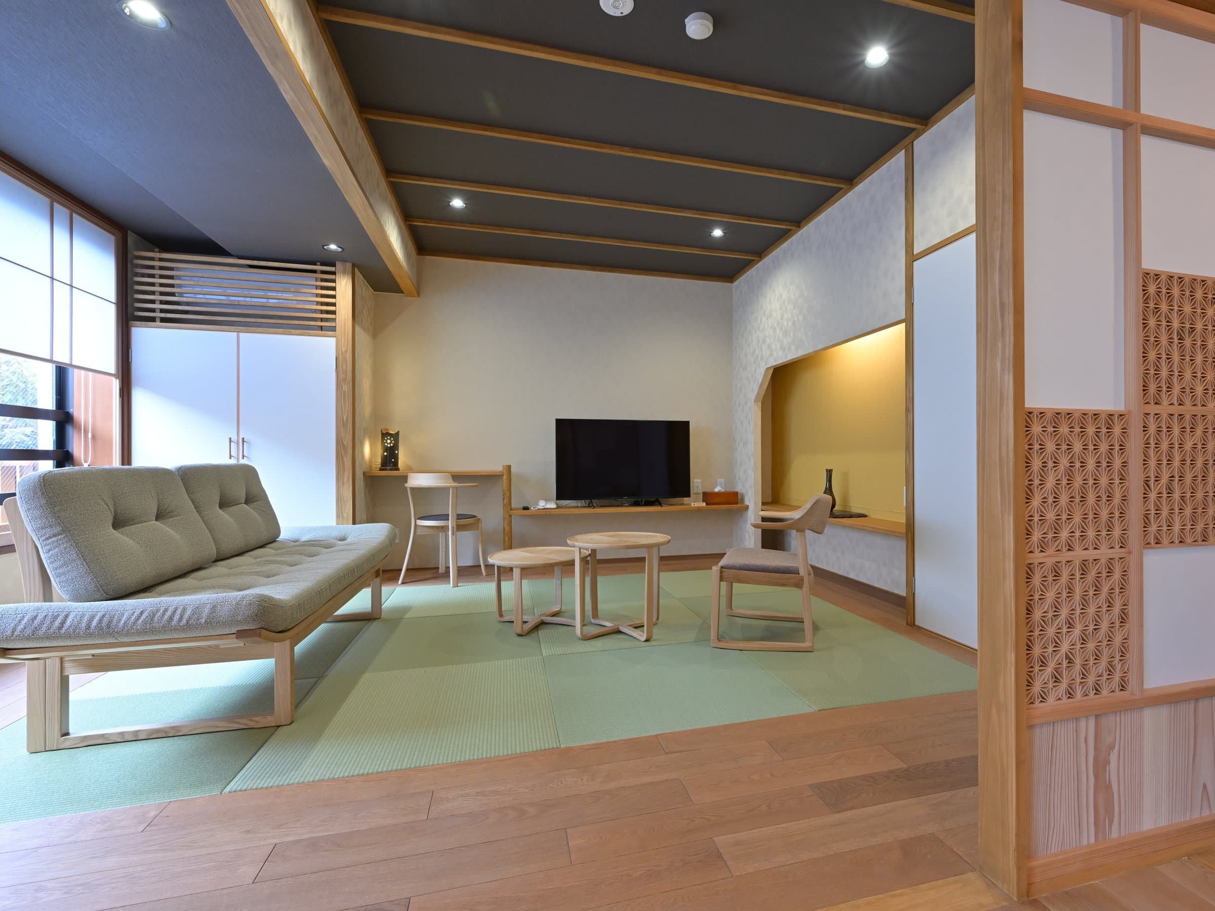 Premium Yuri suite at Ryokan Tamura with a tatami living area, sofa and wooden flooring