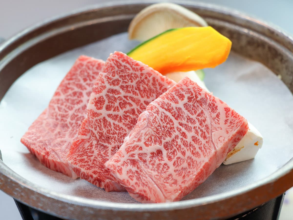 Marbled wagyu beef course served on a hot stone with vegetables as part of Showakan's kaiseki dinner