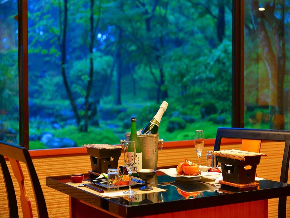 Private in-room dining table at Nikko Hoshi no Yado set with sparkling wine before a dusk forest garden view