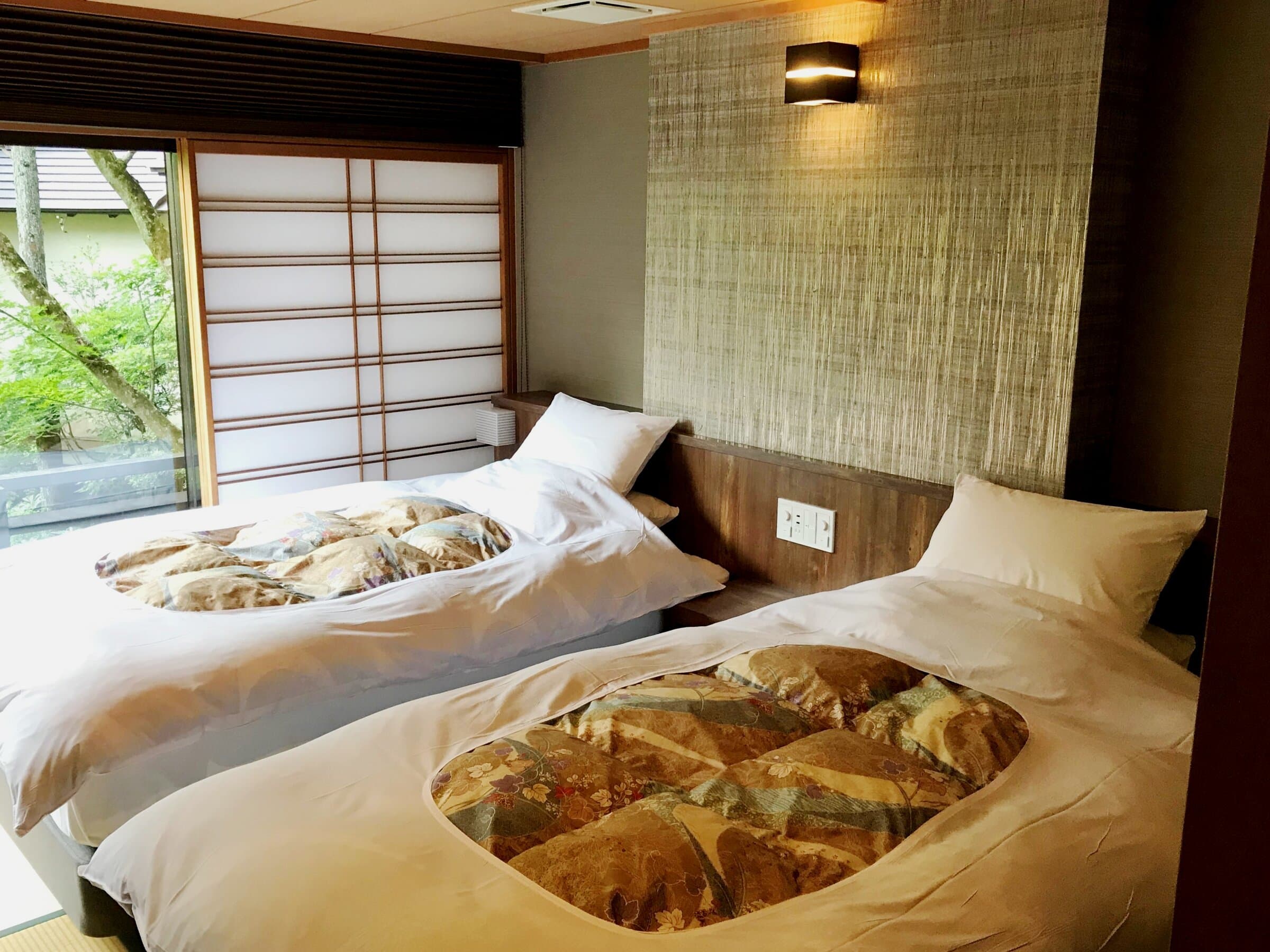 Japanese-modern twin bedroom at Nikko Hoshi no Yado with shoji screens and greenery outside the window
