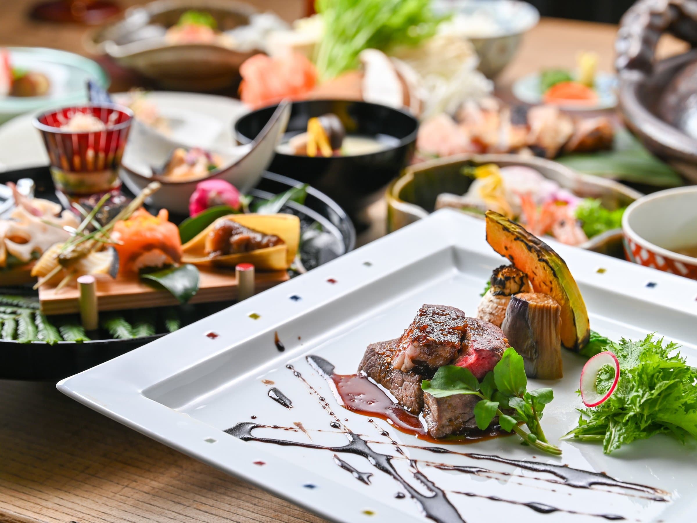 Kaiseki dinner spread with a grilled wagyu beef main course on a blue patterned plate at Ikkoten in Yufuin