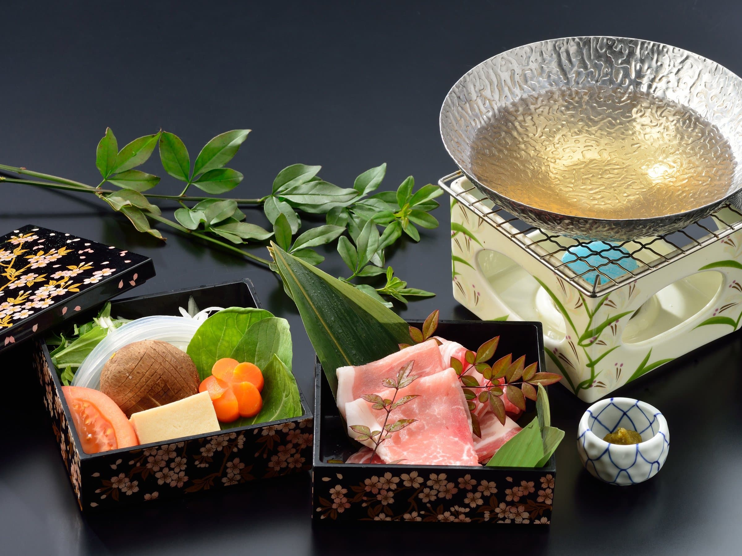 Kagoshima kuro-buta pork shabu-shabu set with lacquer boxes of vegetables and a gold-rimmed pot