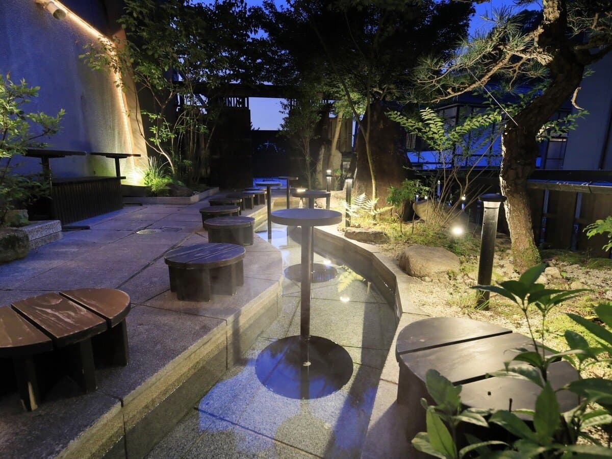 Illuminated garden terrace with stone paths and low stools at Hotel Kikunoya on Miyajima island at dusk