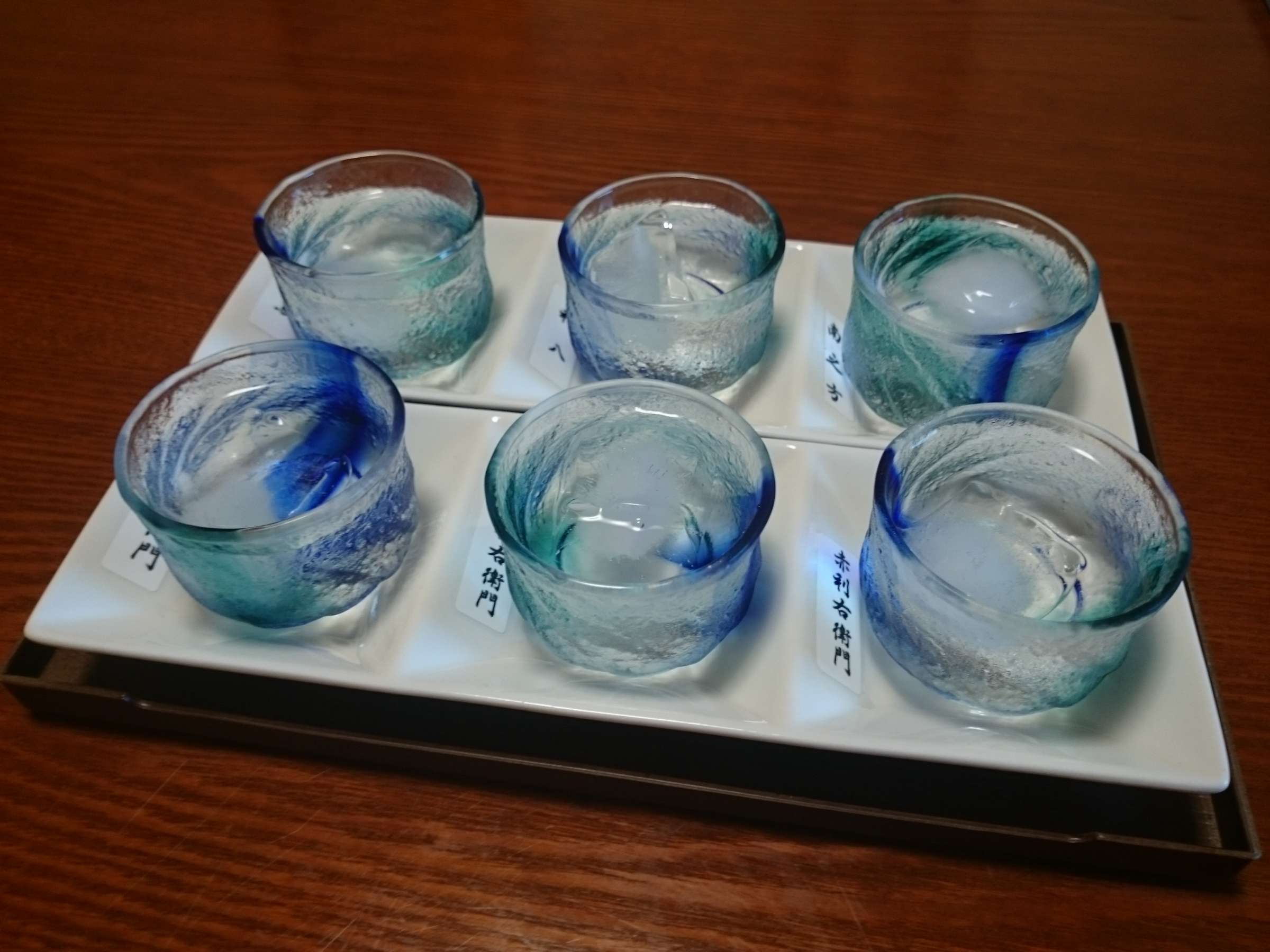 Ibusuki sweet-potato shochu tasting set served in Ryukyu-style blue glasses at Ryokan Tsukimiso