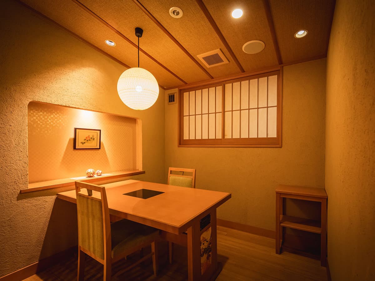 Private Japanese dining room at Dogo Prince Hotel with a wooden table, paper lantern light and earthen plaster walls