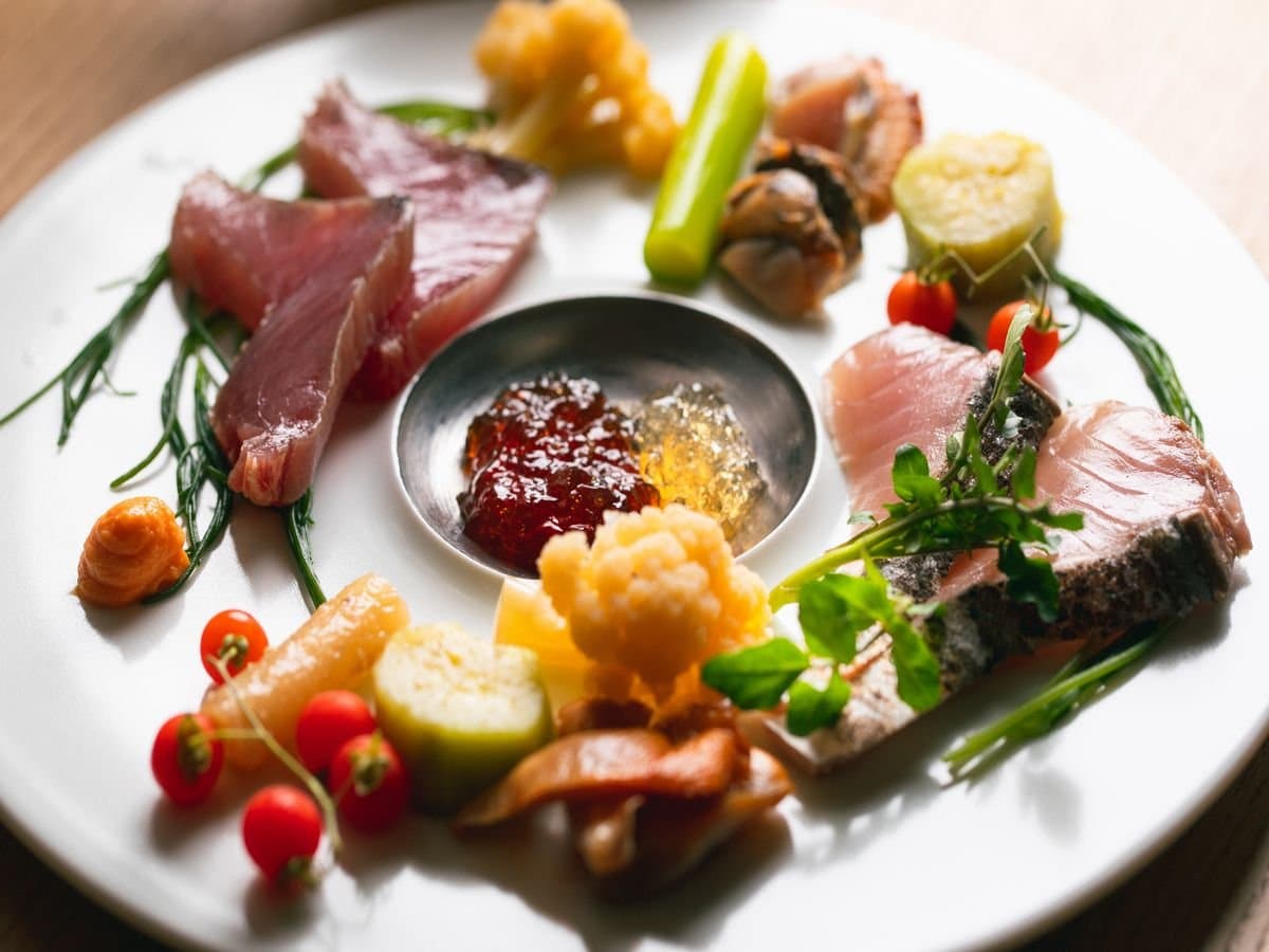 Seasonal kaiseki appetizer platter at Umenoya featuring Ehime seafood, vegetables and tomatoes on a white plate