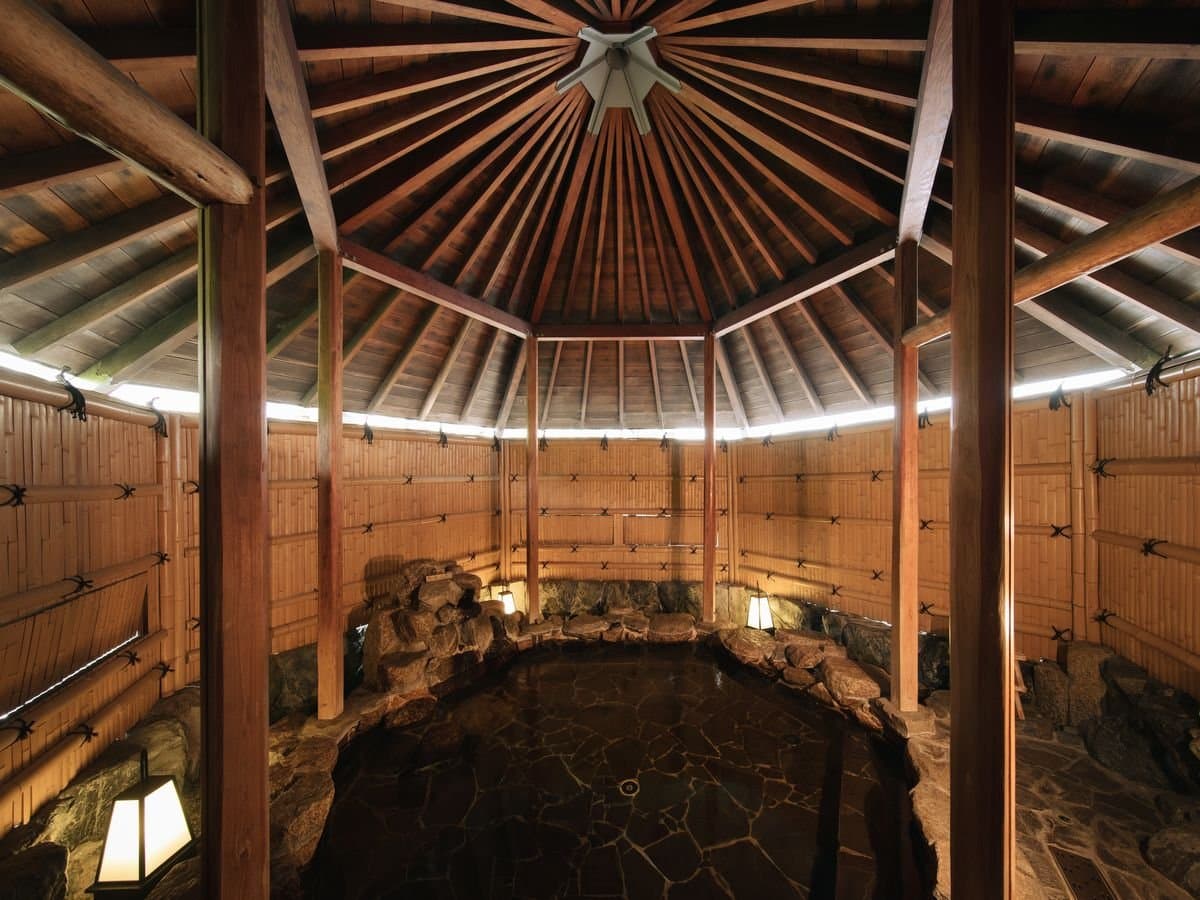 Mori-no-Yu half open-air bath at Umenoya with a stone tub under a domed timber ceiling and bamboo-lined walls