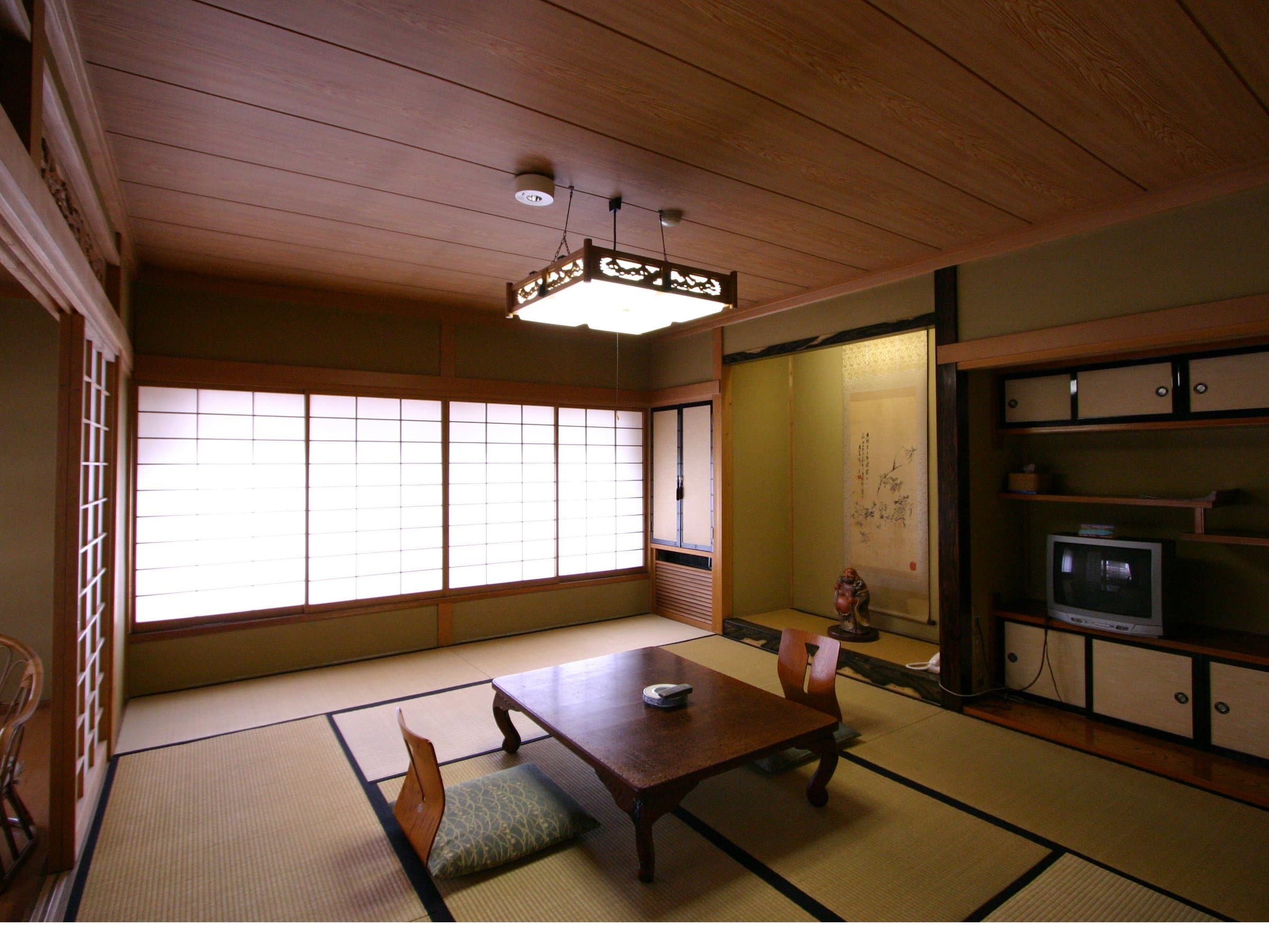 Spacious tatami guest room with low wooden table, hanging lantern light and shoji screens