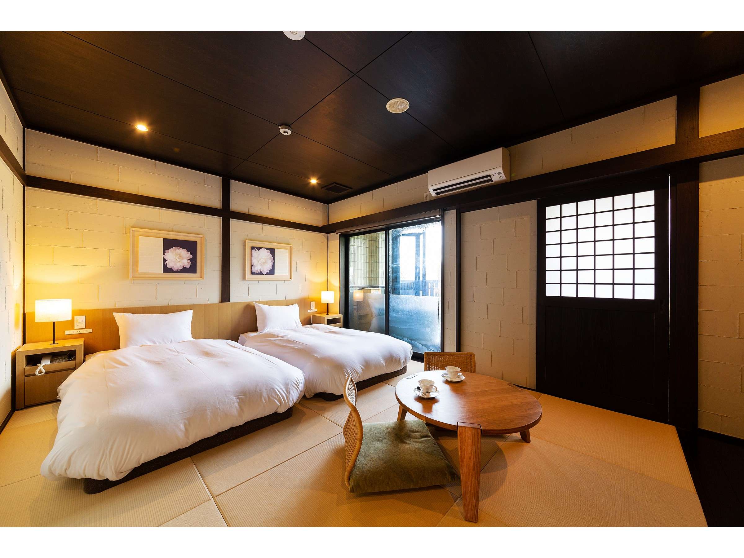 Japanese-style twin guest room at Bisei Yufuin with shoji screen, low wooden table and warm lighting