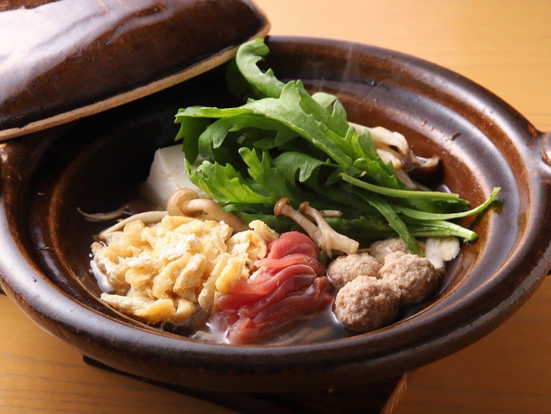 Steaming clay-pot nabe hotpot with chicken, mushrooms and greens served at Bisei Yufuin