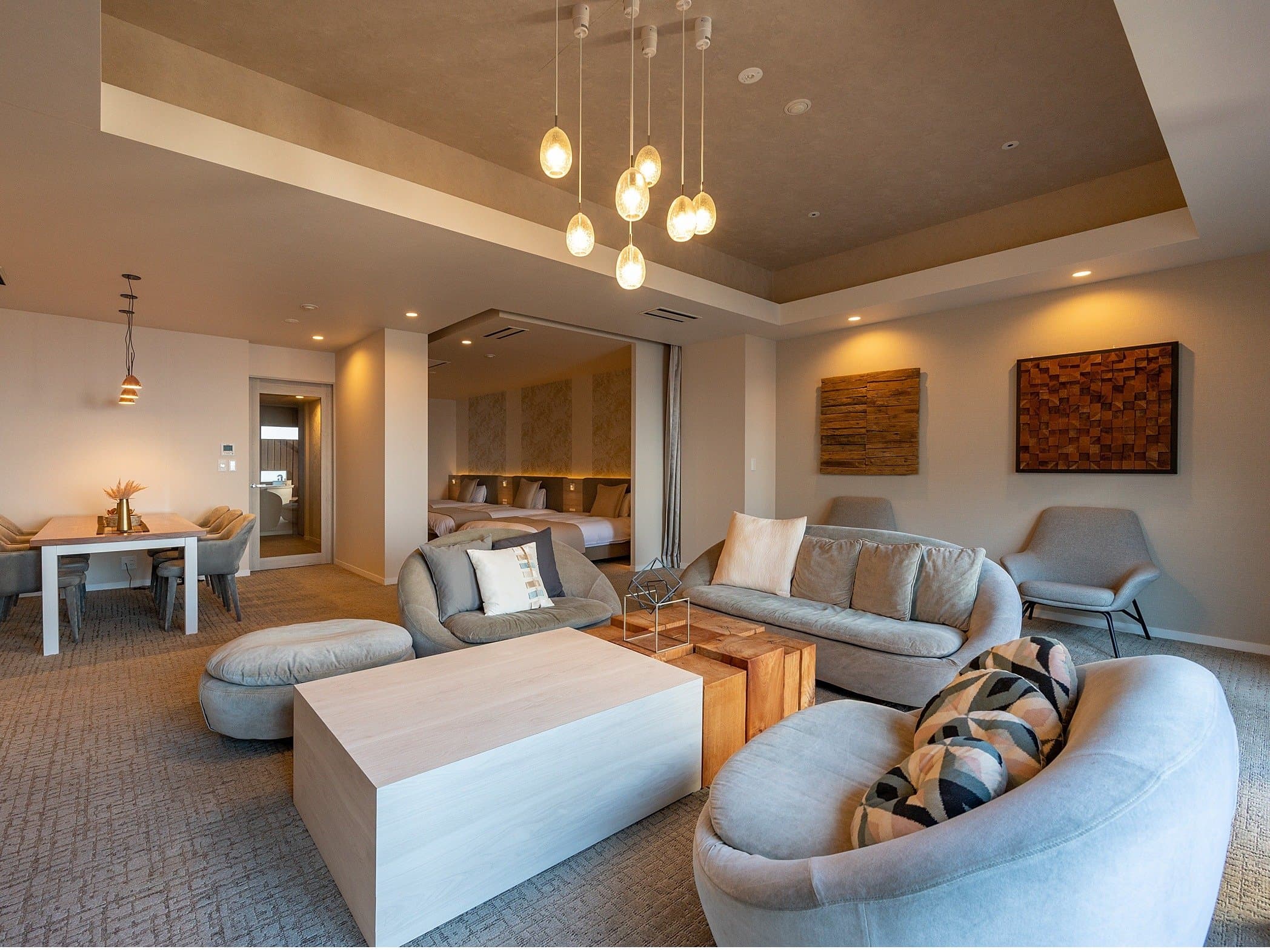 Premium suite living room with sofas, designer lighting and bedroom alcove at ISHINOYA Atami